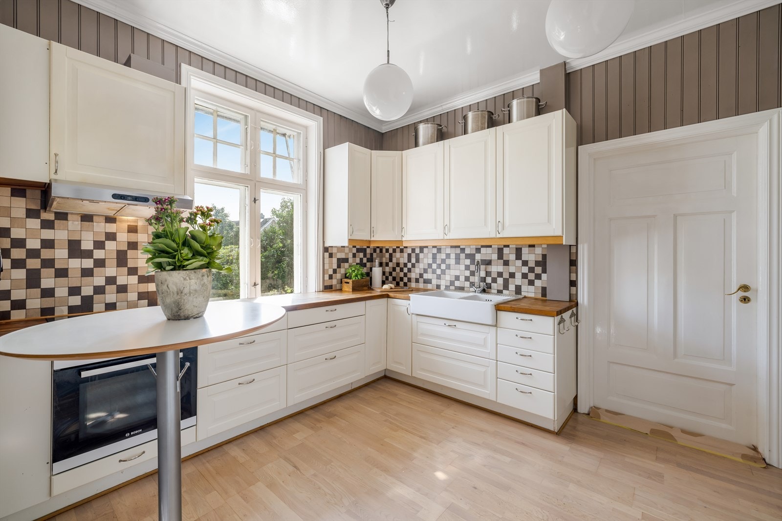 Lekkert kjøkken med plass til spisebord langs vegg. Integrerte hvitevarer er kjøleskap, oppvaskmaskin, stekeovn og platetopp. Galleribilde