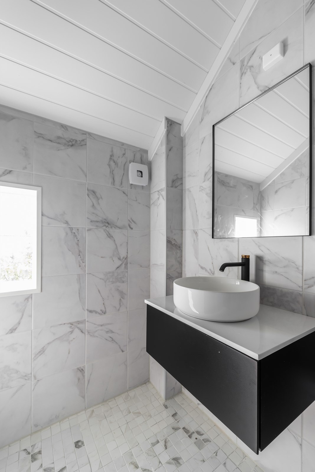 Badet er innredet med dusjhjørne og stilig innredning med nedfelt servant og speil over. Marmor var vanlig på tiden boligen ble bygget. Galleribilde