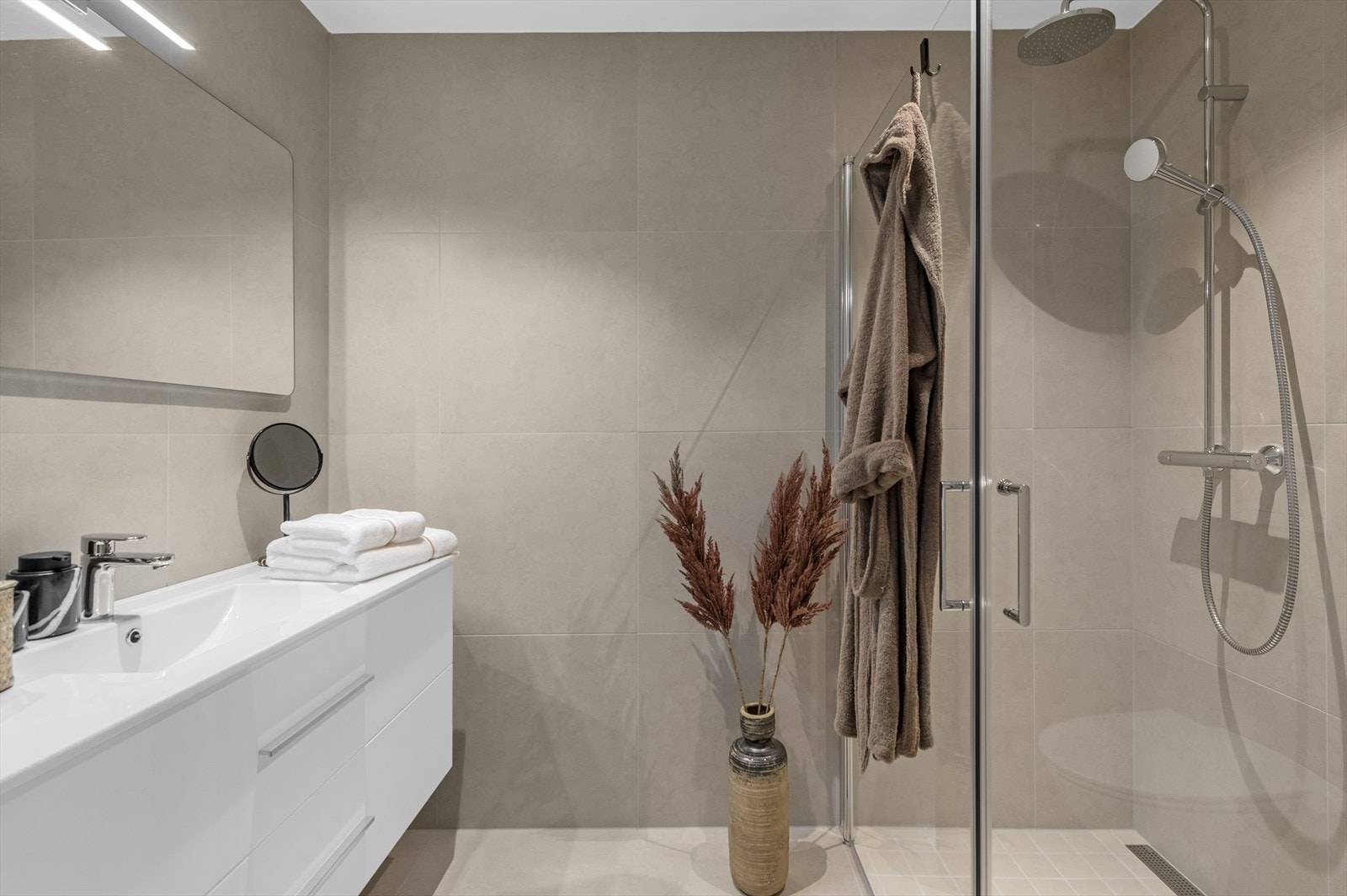 Hovedbadet er flislagt og er utstyrt med toalett, dusj og servant. Dusjhjørne med innfellbare dusjvegger Galleribilde