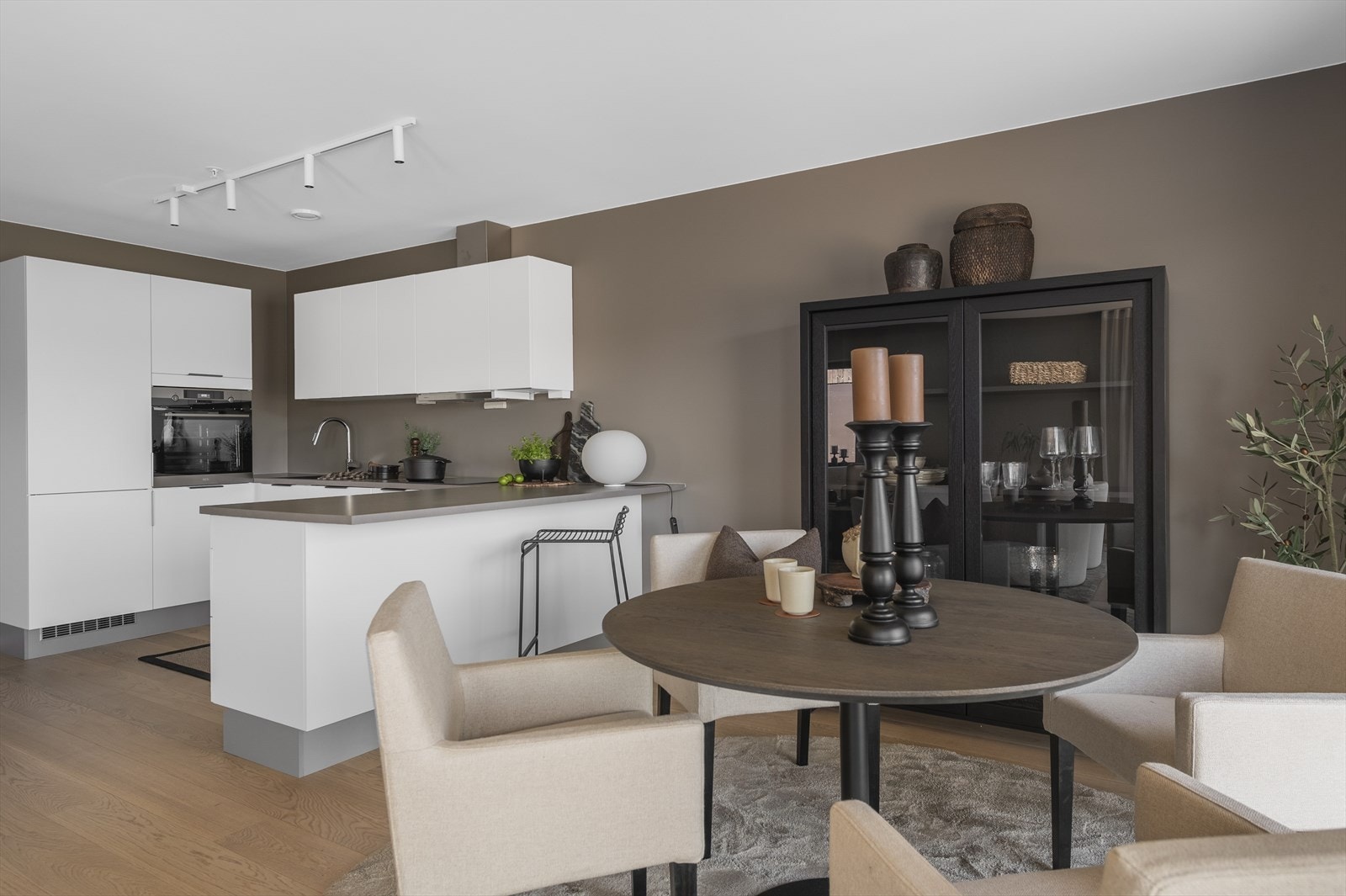 Kjøkkenet har barløsning som skaper naturlig skille mellom kjøkken og spiseplass Galleribilde