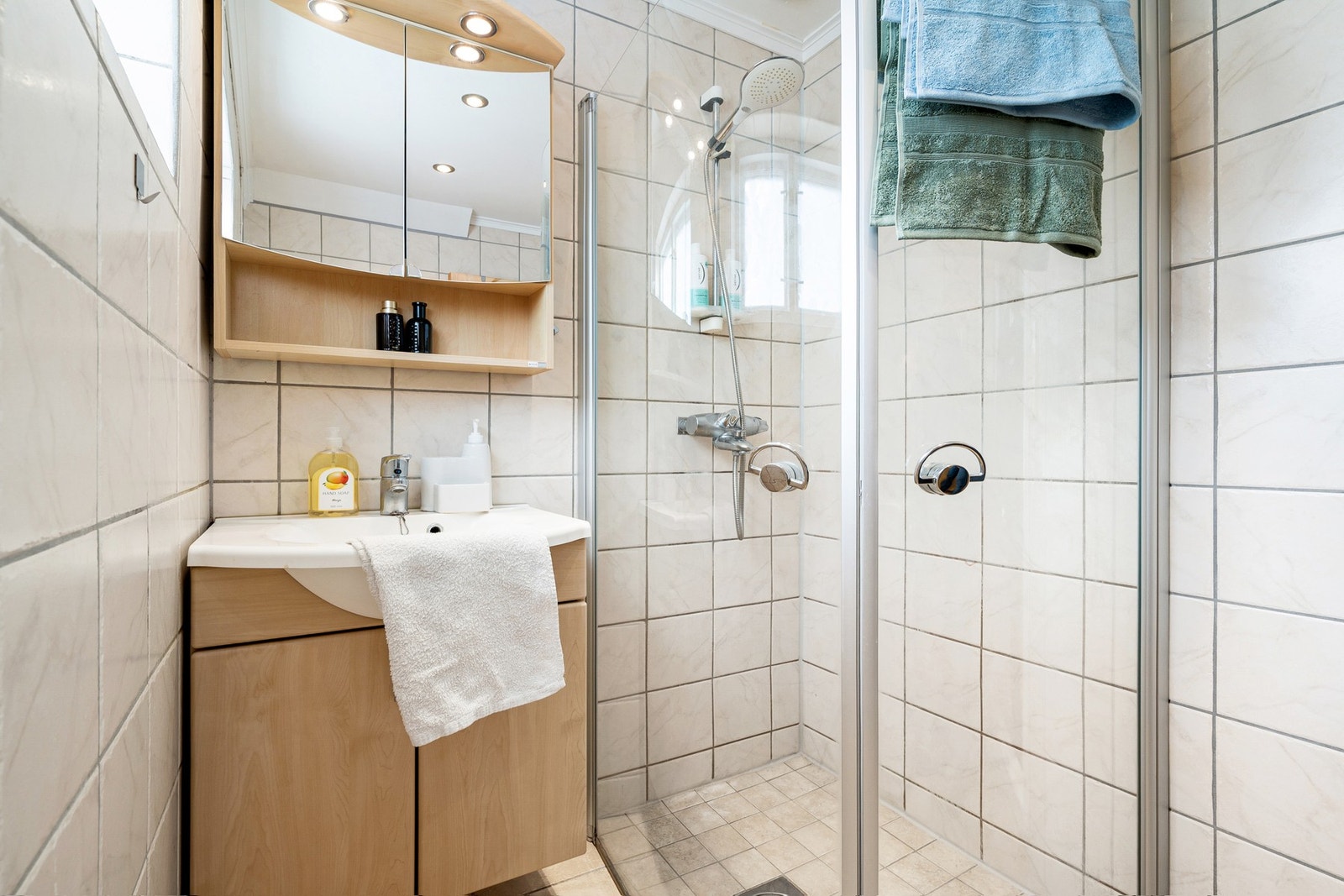 Badet har varmekabler i gulv og opplegg for vaskemaskin i hjørnet. Galleribilde