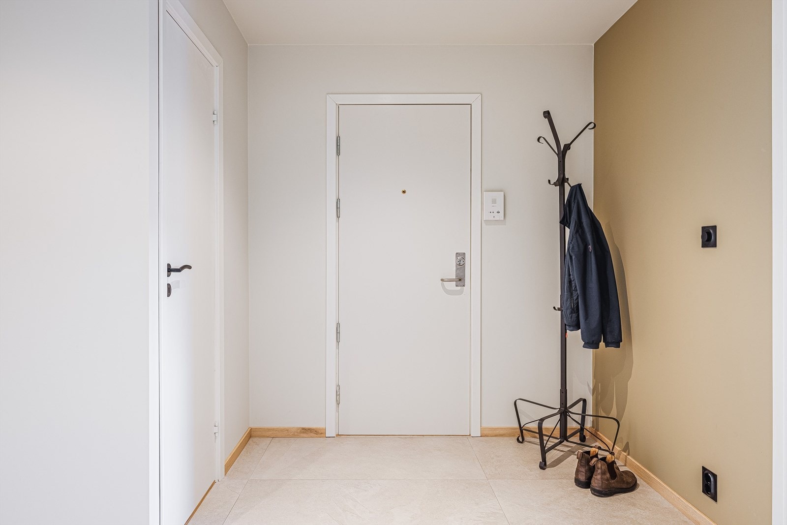 Romslig entré med store flotte fliser på gulv, glatte malte overflater og downlights i himlingen. Det er trappeadkomst opp til leiligheten som ligger i byggets 3. etasje. Galleribilde