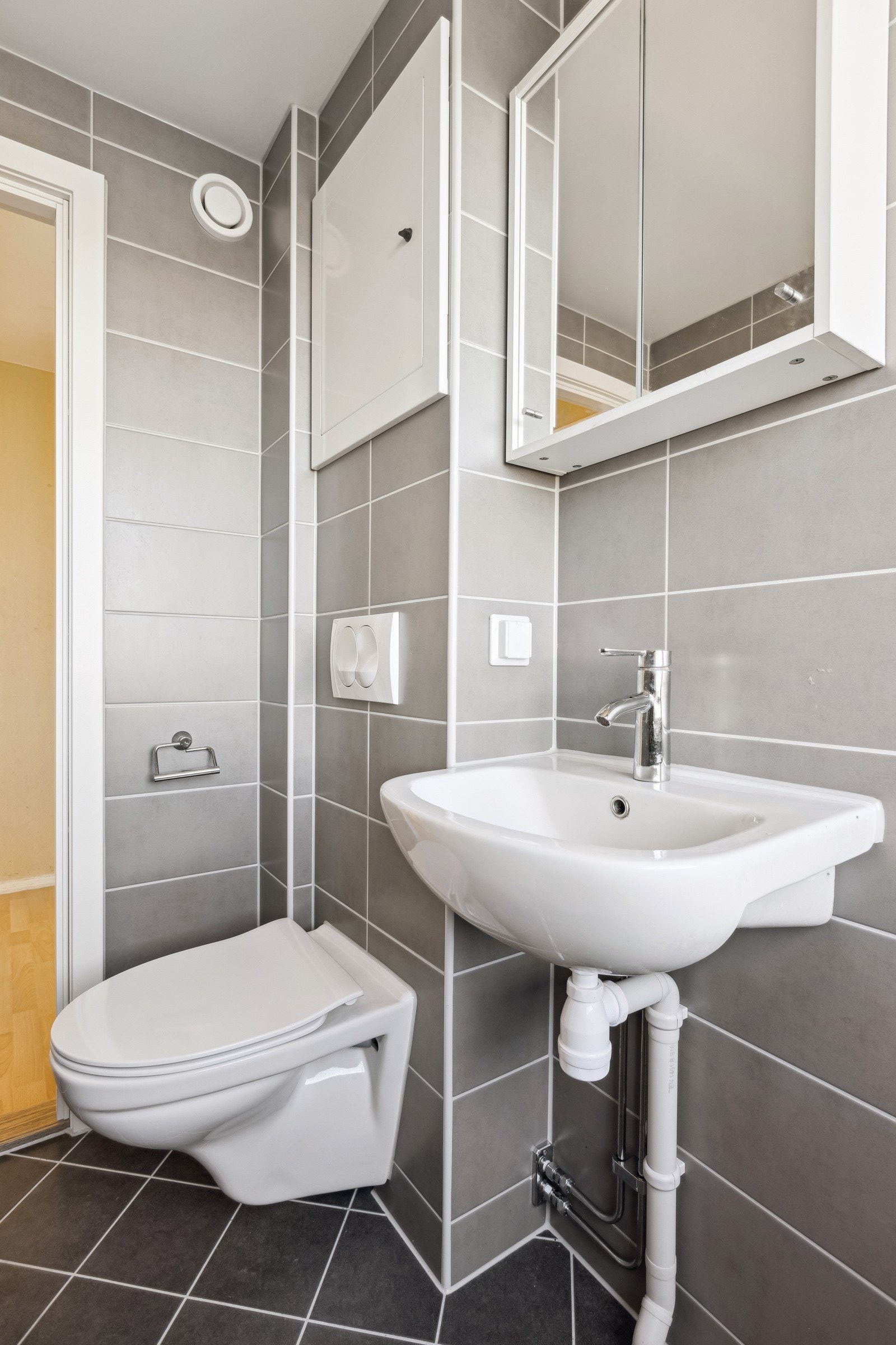 Varmekabler i gulv. Vegghengt toalett, servant med overskap, dusj i hjørne med glassvegg. Opplegg for vaskemaskin. Galleribilde