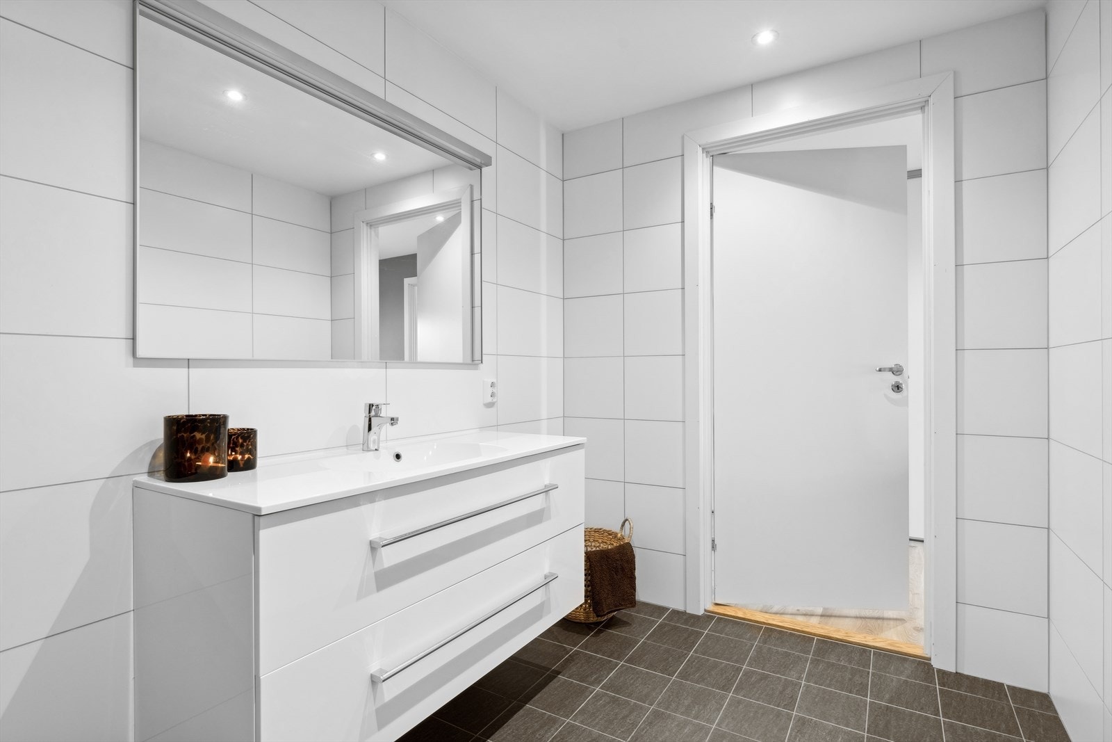 Badet er innredet med veggmontert wc, servantinnredning og dusjvegger. Galleribilde