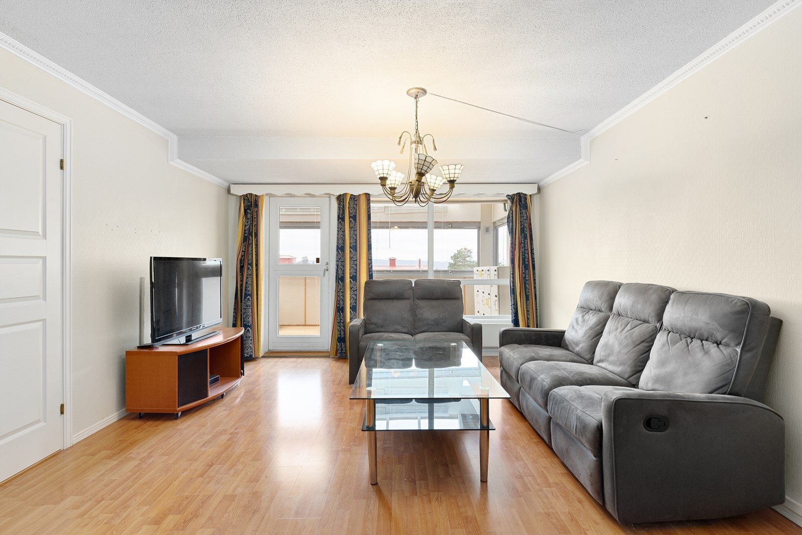 Lys stue med videre utgang til innglasset balkong Galleribilde