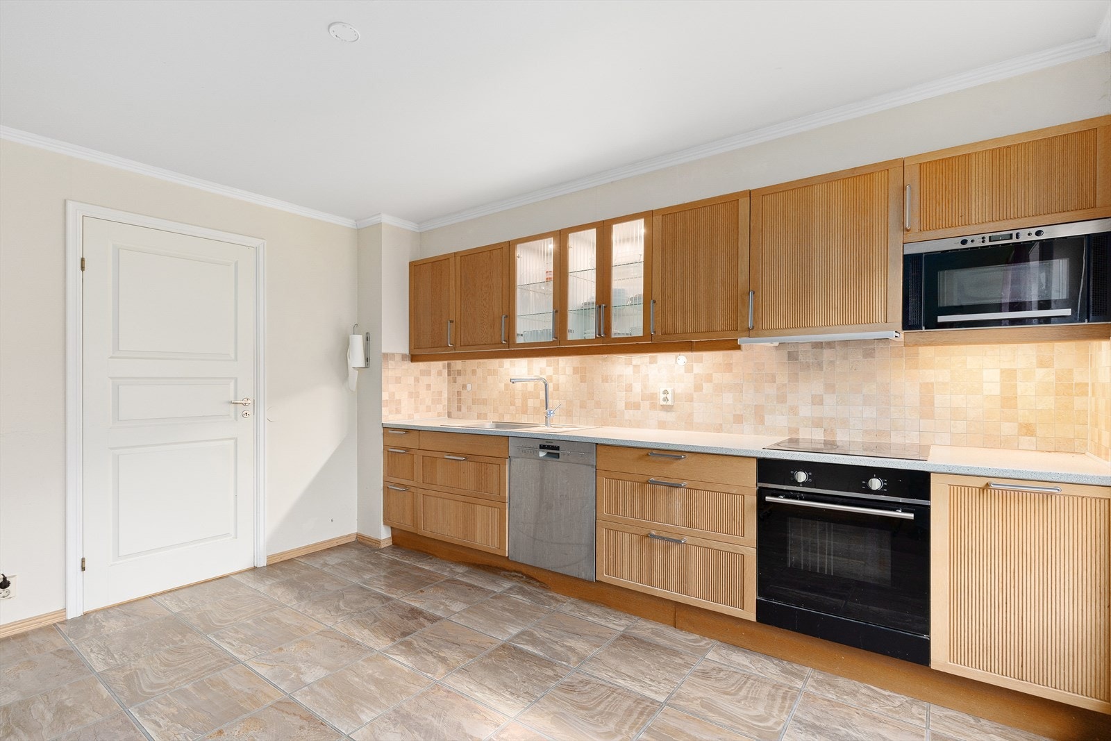 Ikea kjøkkeninnredning i trefarge med profilerte fronter. Enkelte skap med vitrineskap med downlights inni. Galleribilde