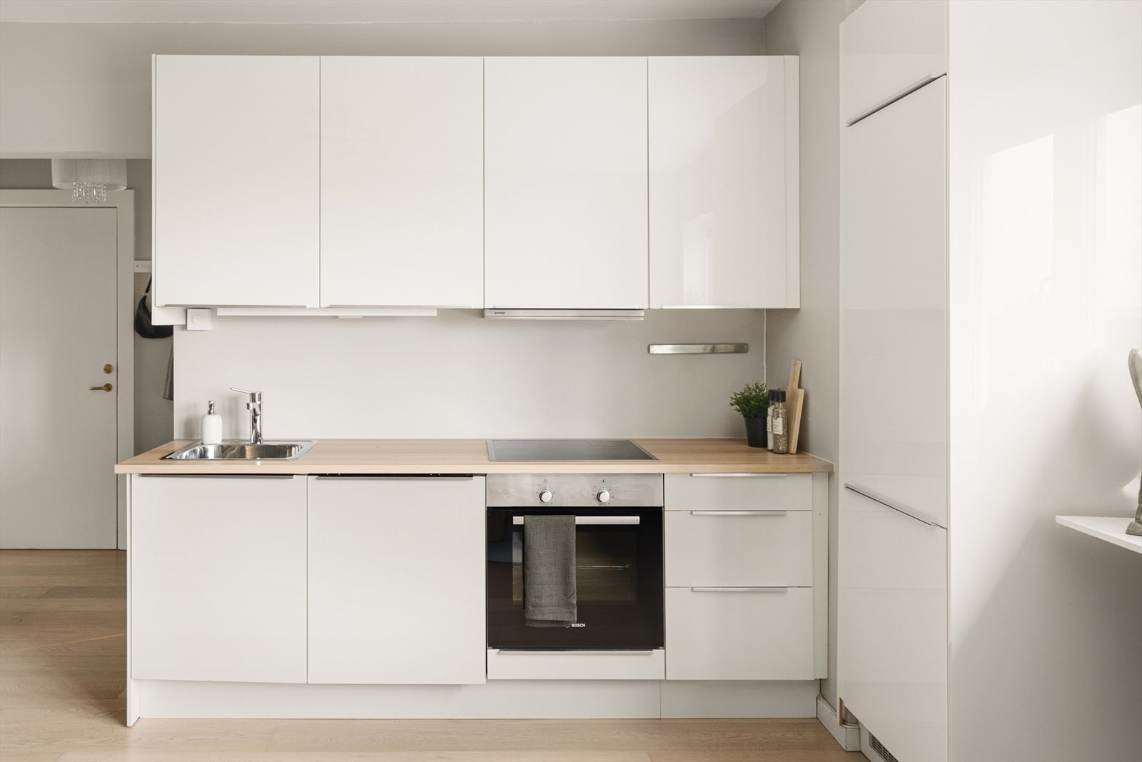 Stilrent kjøkken fra 2015 med hvite fronter og pen laminert benkeplate. Galleribilde