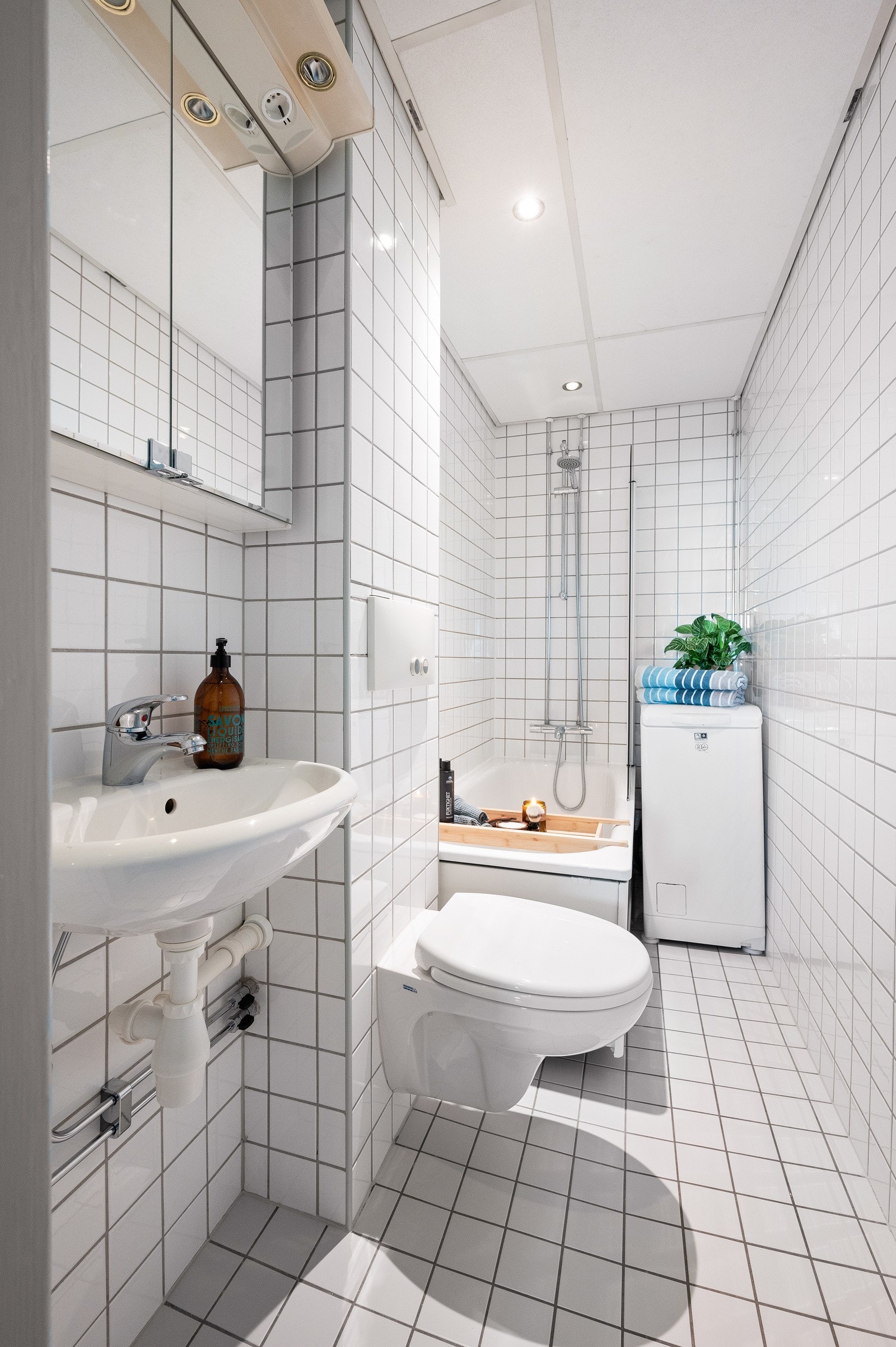 Flislagt bad med varmekabler i gulv, downlights i himling og opplegg for smal vaskemaskin. Galleribilde