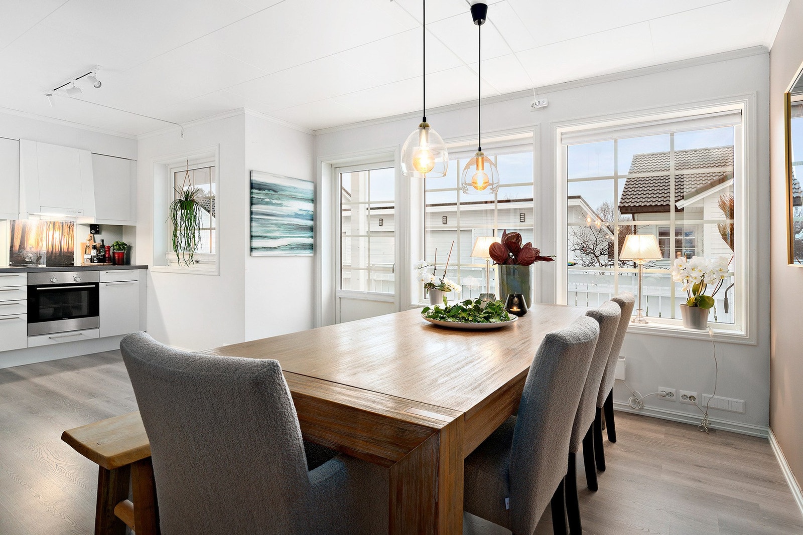 Legg merke til det gedigne spisebordet, som passer perfekt uten at stua virker trang og overmøblert Galleribilde