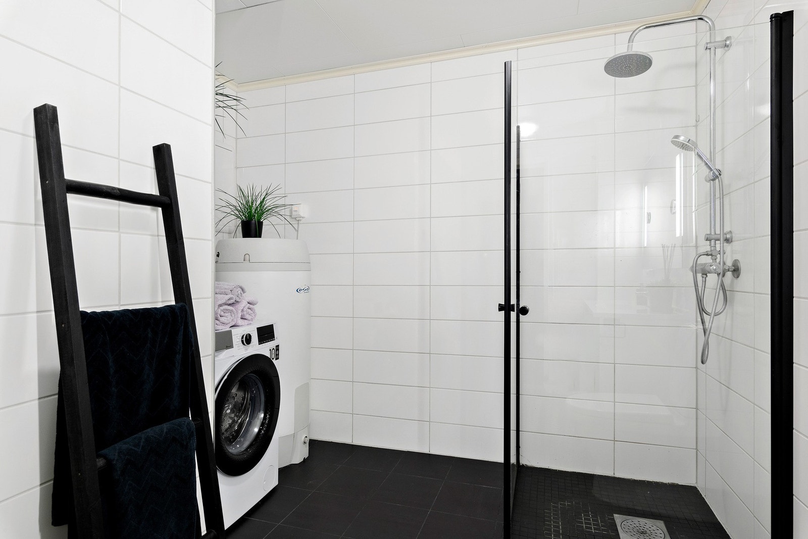 Bad har tilpasset plass for vaskemaskin og varmtvannstank. Bak planten på varmtvannstanken finnes inspeksjonsluke for rør-i rør opplegg. Galleribilde