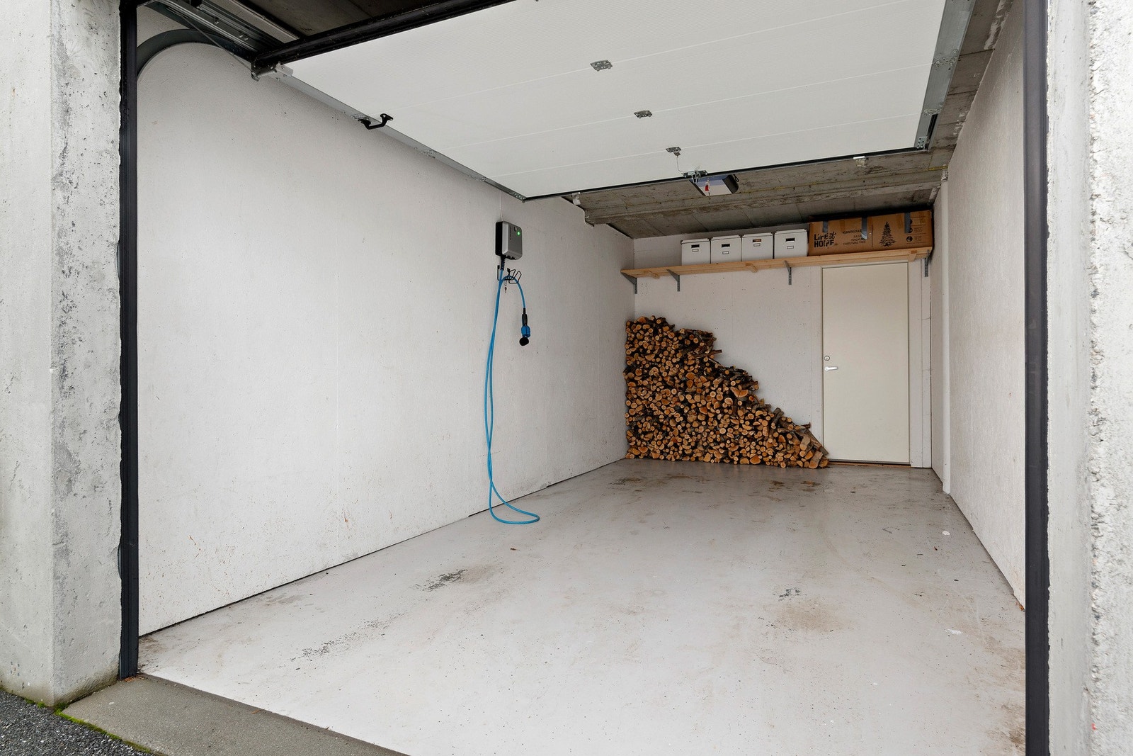 i Tillegg til den innvendige bode, bak stue, har man bod i tilknytning til garasje. Legg merke til elbil- lader som er montert. Galleribilde