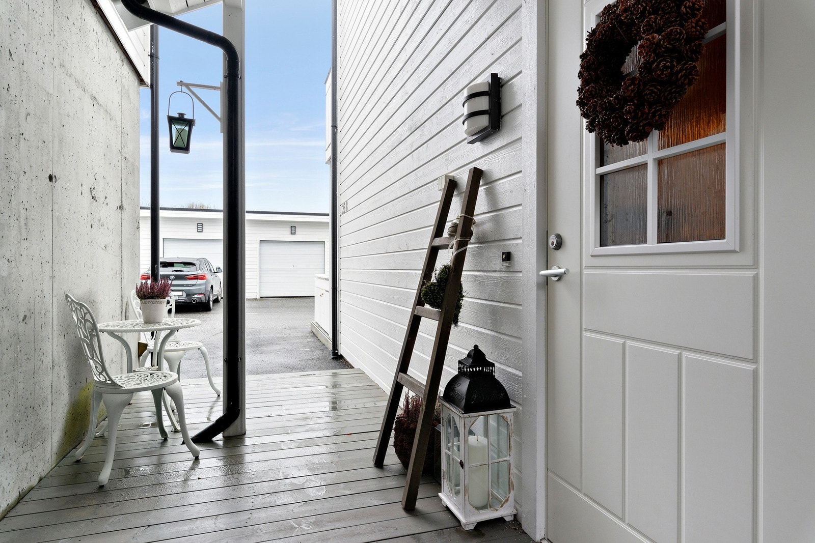 Overbygd inngangsparti med pene detaljer som belysning og oppheng for lykt og/eller blomster Galleribilde