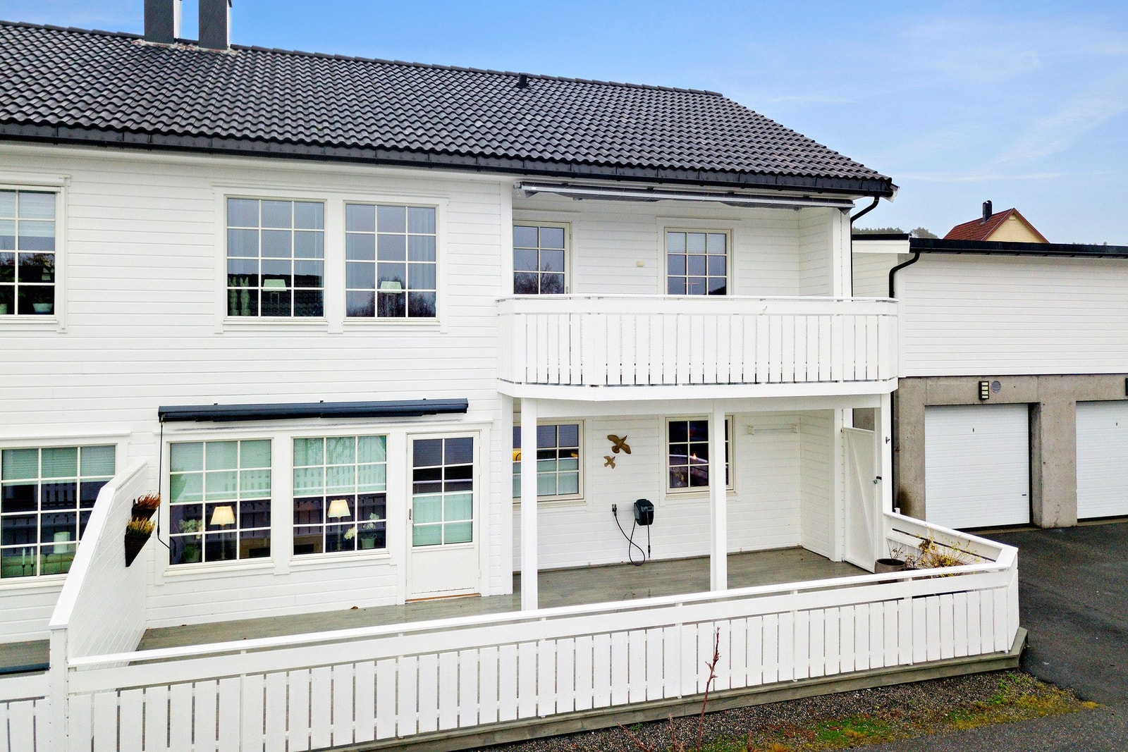 Terrassen vender mort vest og over stuevindu og verandadør er det markise. Galleribilde