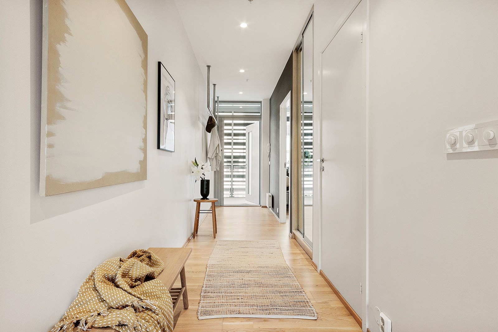 Romslig entré hvor det er god plass til å henge fra seg yttertøy i plassbygde garderobeskap Galleribilde