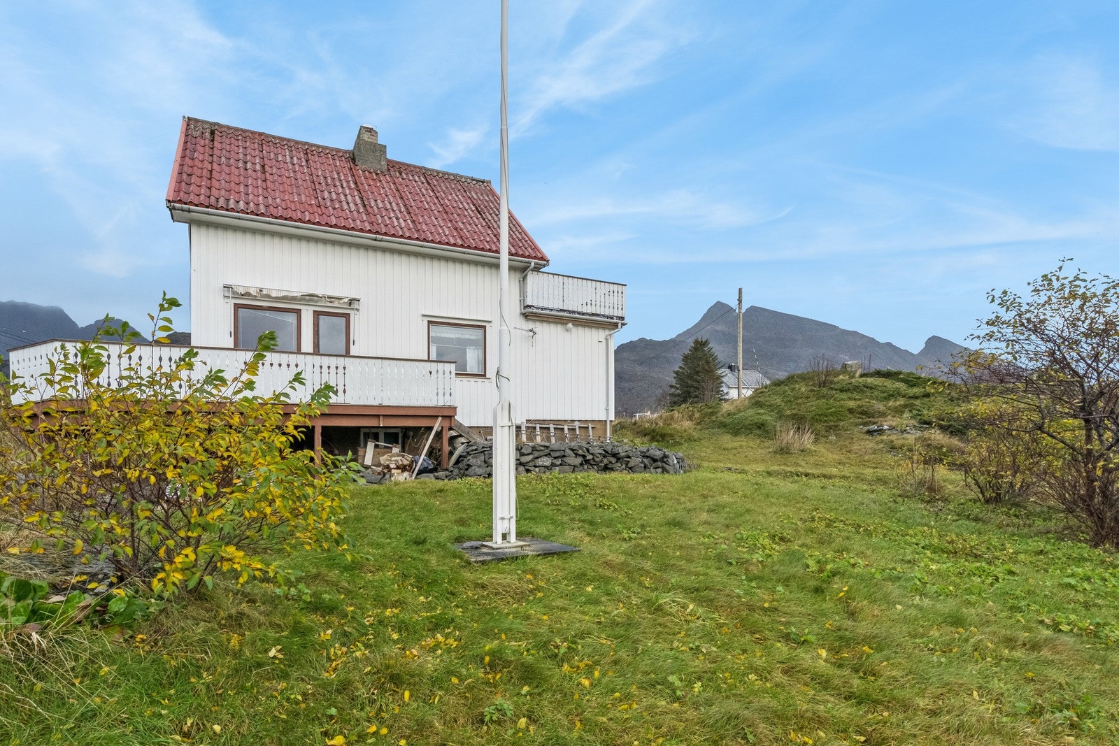 Boligen har noe opparbeidet plen med diverse prydbuser Galleribilde