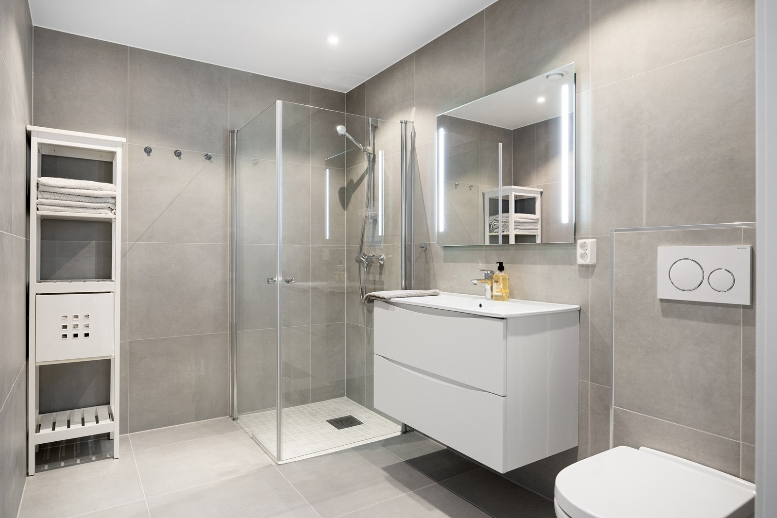 Hovedbadet er et stilrent, flislagt baderom med innfelte downlights og elektrisk gulvvarme. Galleribilde