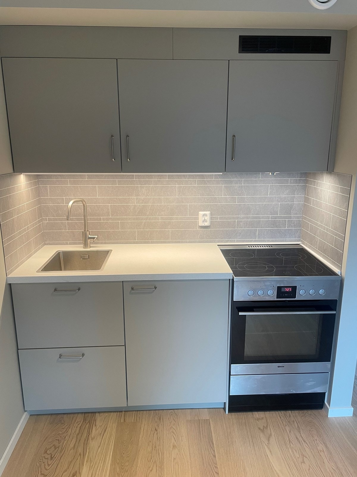 Stilrent kjøkken med god skap- og benkeplass. Kjøkkenet har glatte fronter og laminat benkeplate med nedfelt vask- og skyllekum. Det er kullfilterventilator over kokeplassen. Galleribilde