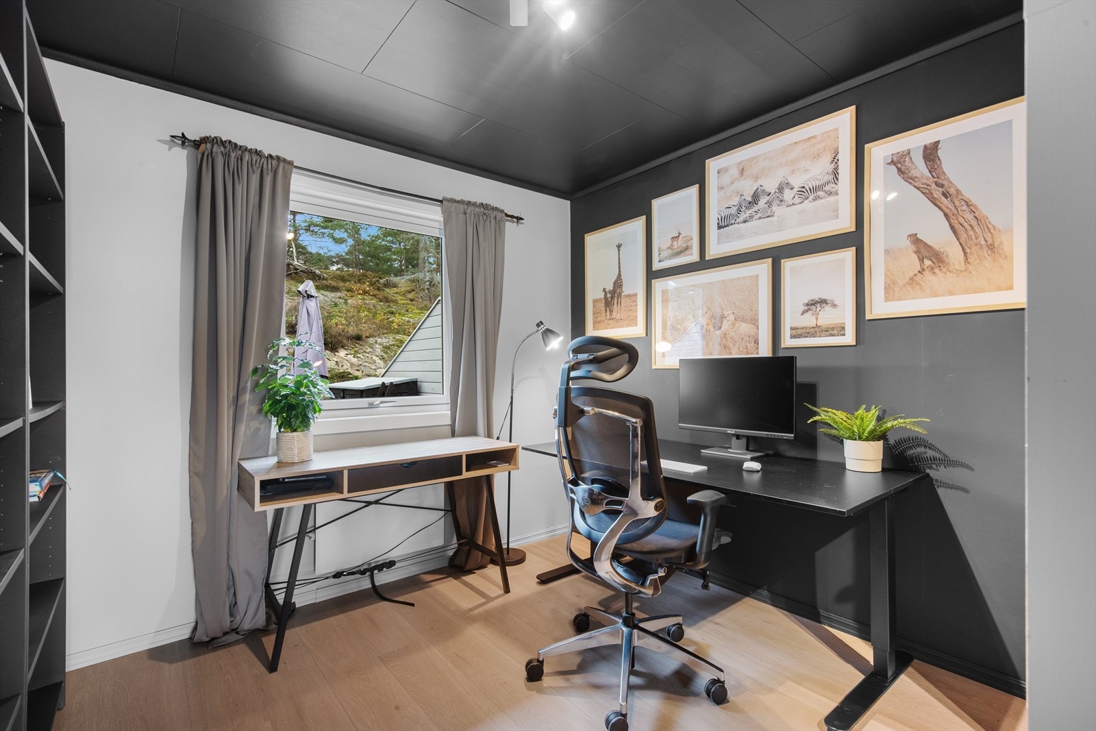 Soverom 2 ligger i 1.etasje og er i dagens løsning innredet som kontor, med utsyn mot terrasse og naturterreng på baksiden av boligen. Galleribilde