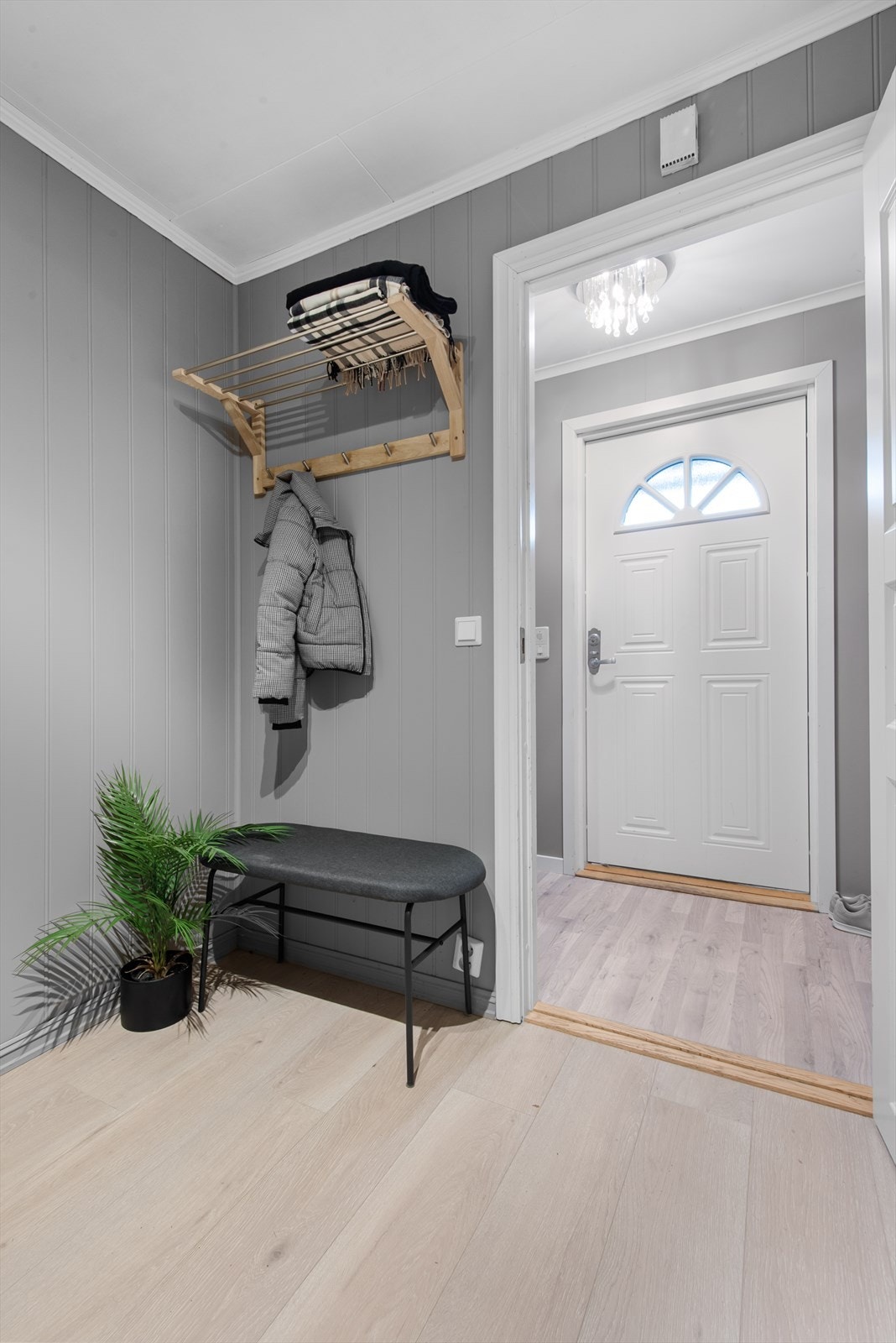 Vel inne er et praktisk vindfang med dør som kan lukkes, og innenfor ligger en romslig gang med plass til garderobemøbel. Galleribilde