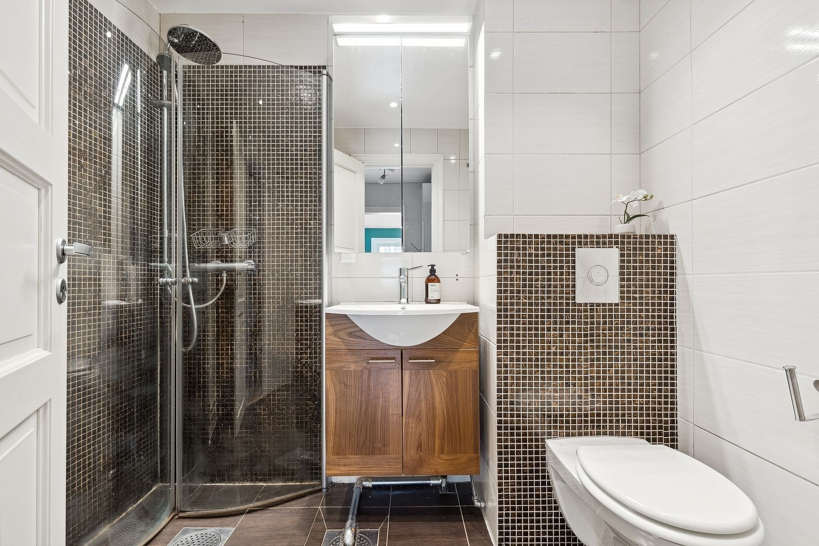 Pent flislagt bad med varme i gul og opplegg for vaskemaskin. Galleribilde