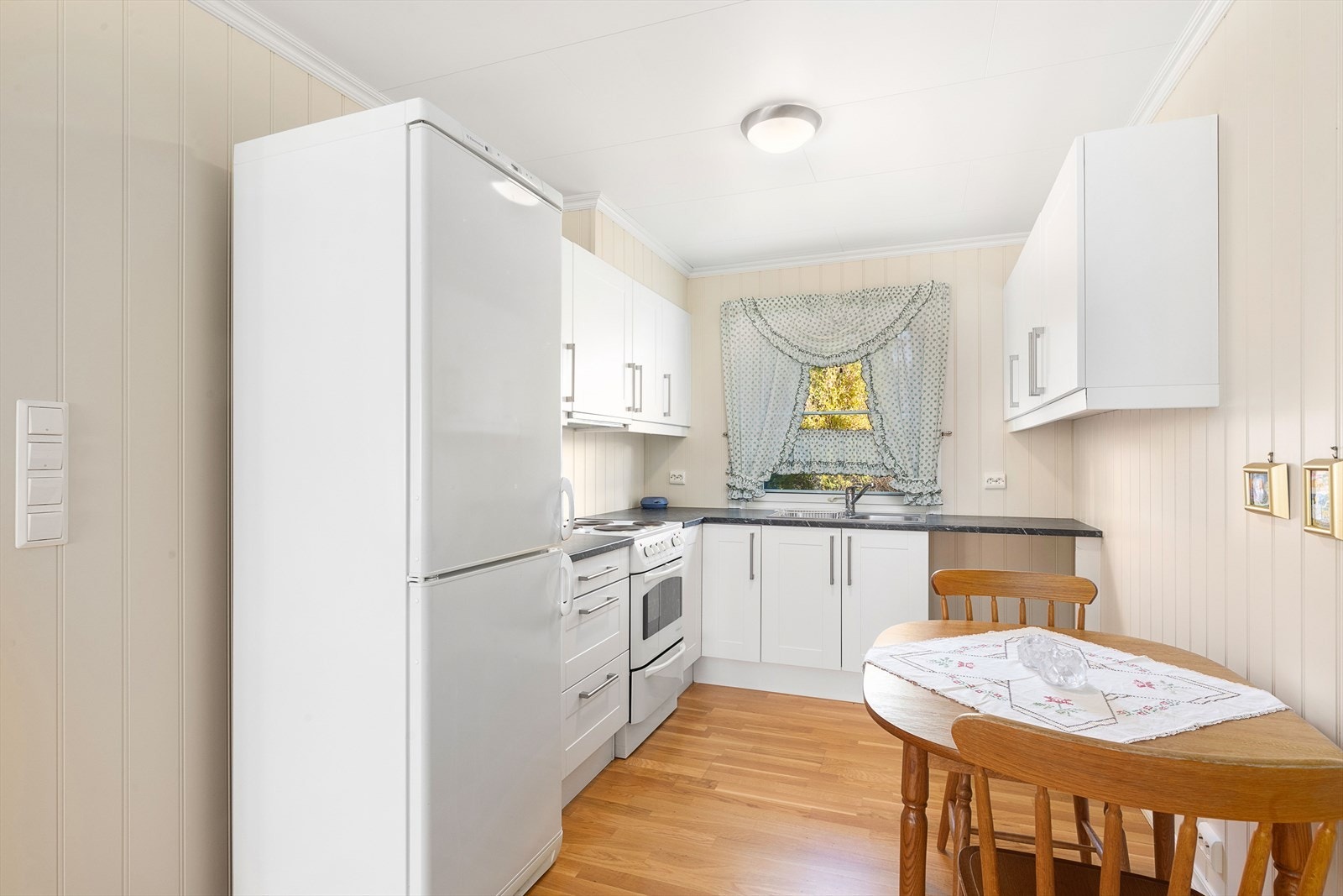 Kjøkken med plass til et lite spisebord. Galleribilde