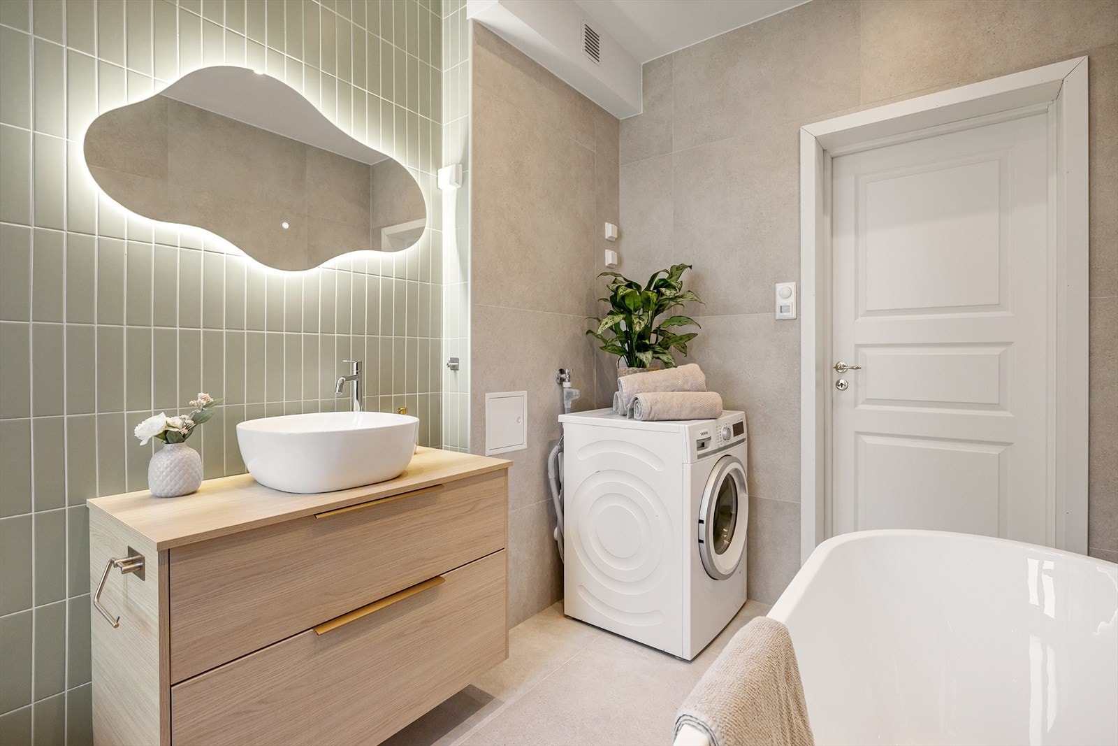 Badet har flislagte overflater, downlights med dimmer og behagelig gulvvarme. Det er opplegg for vaskemaskin. Galleribilde