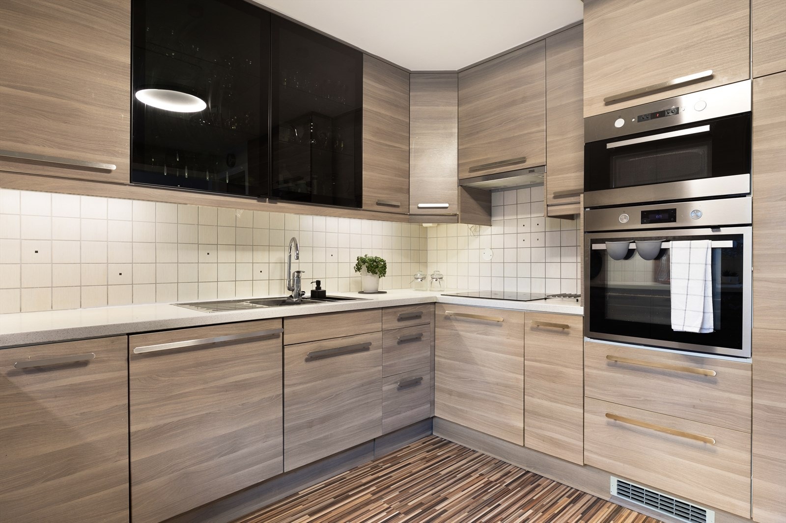 Kjøkkenet har integrerte hvitevarer som nedfelt platetopp, stekeovn, mikroovn, oppvaskmaskin og kjøl-/fryseskap Galleribilde