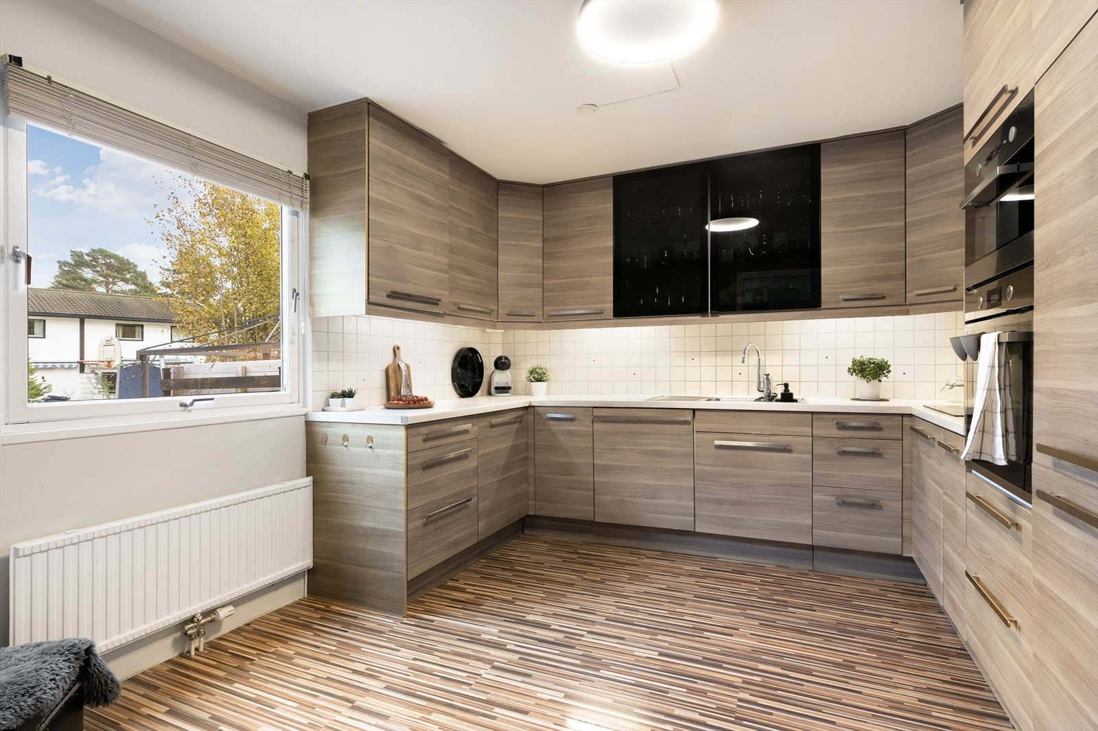 Romslig kjøkken med rikelig skap- og benkeplass, laminert innredning og benkeplate med nedfelt oppvaskkum Galleribilde