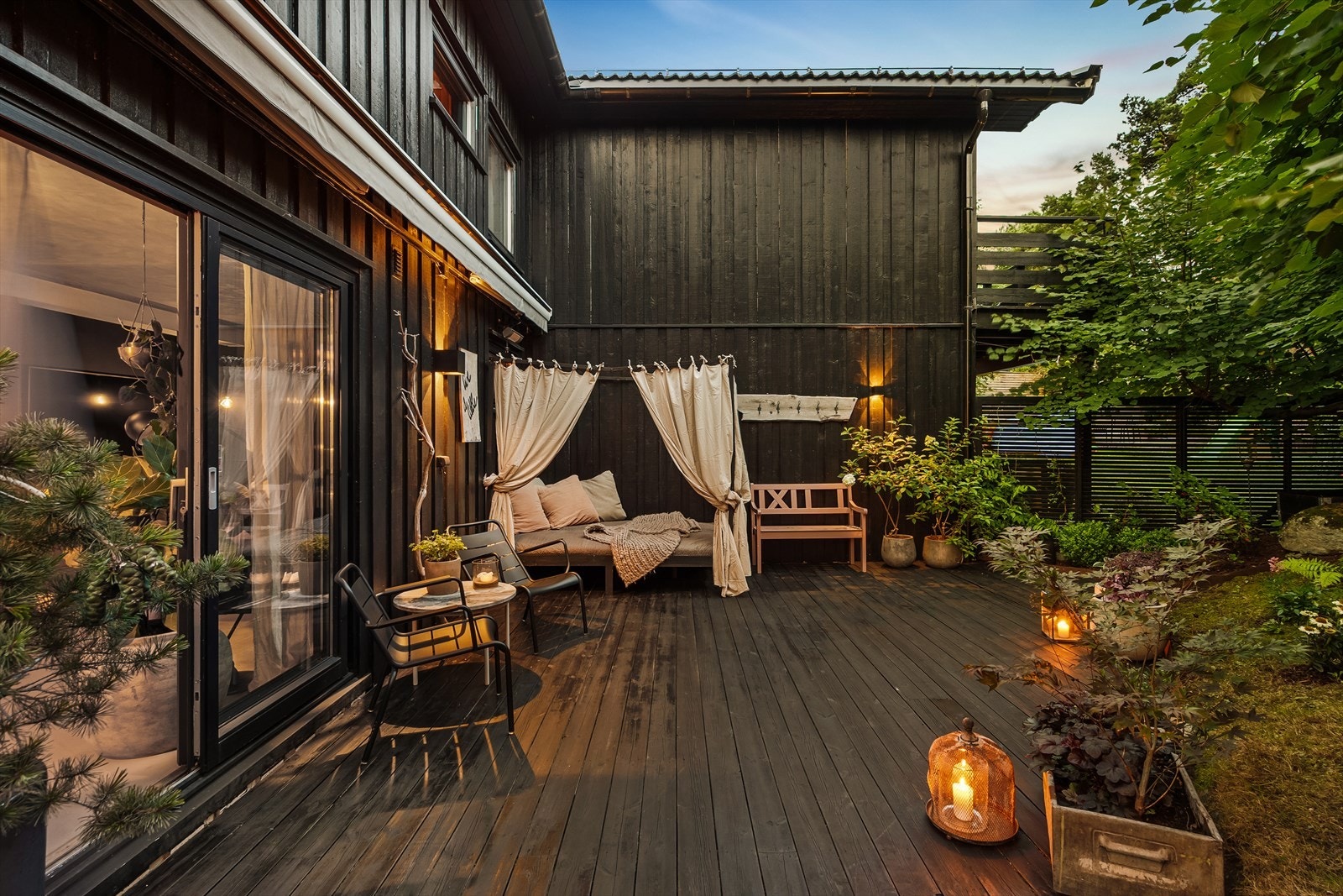 Terrassen på hele 110 m² strekker seg rundt boligens 1. etasje - Praktisk utforming med flere soner gir god plass til langbord og grill samt et flott lounge-område Galleribilde