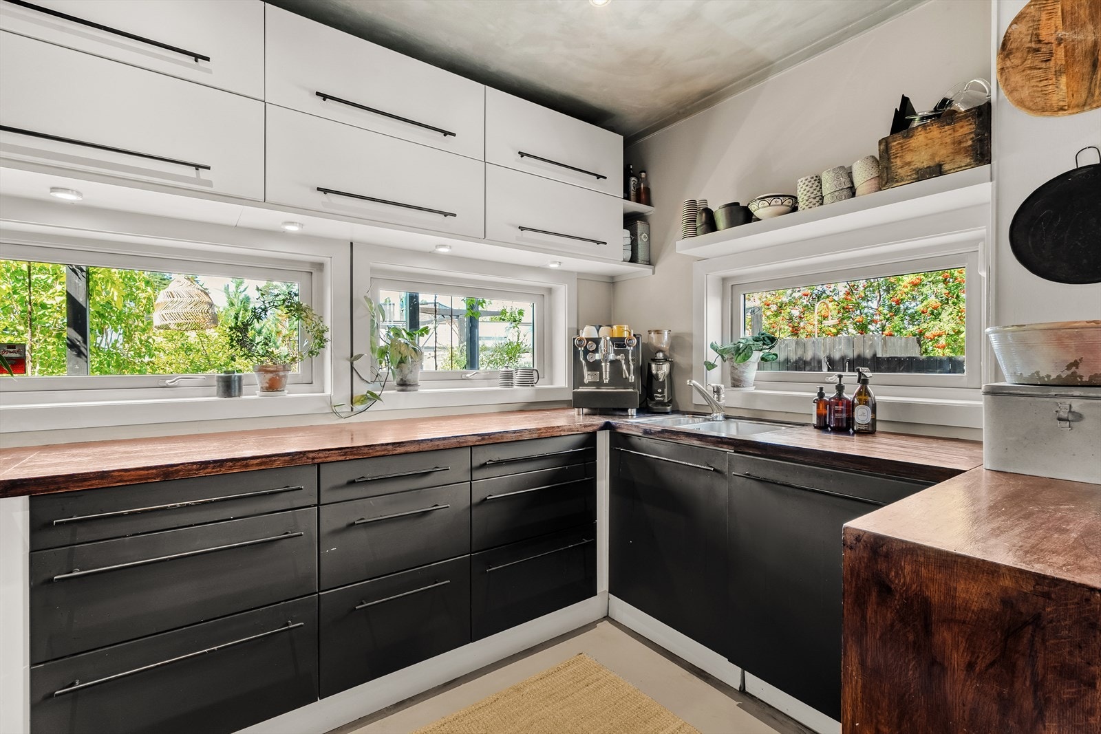 Vinduene mellom kjøkkenbenken og overskapene sikrer gode lysforhold på kjøkkenet Galleribilde