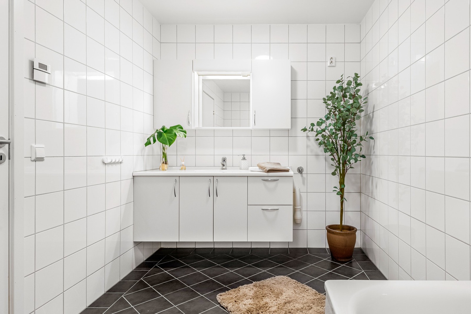 Det er plass for vaskemaskin på badet og servantinnredningen har glatte fronter. Galleribilde