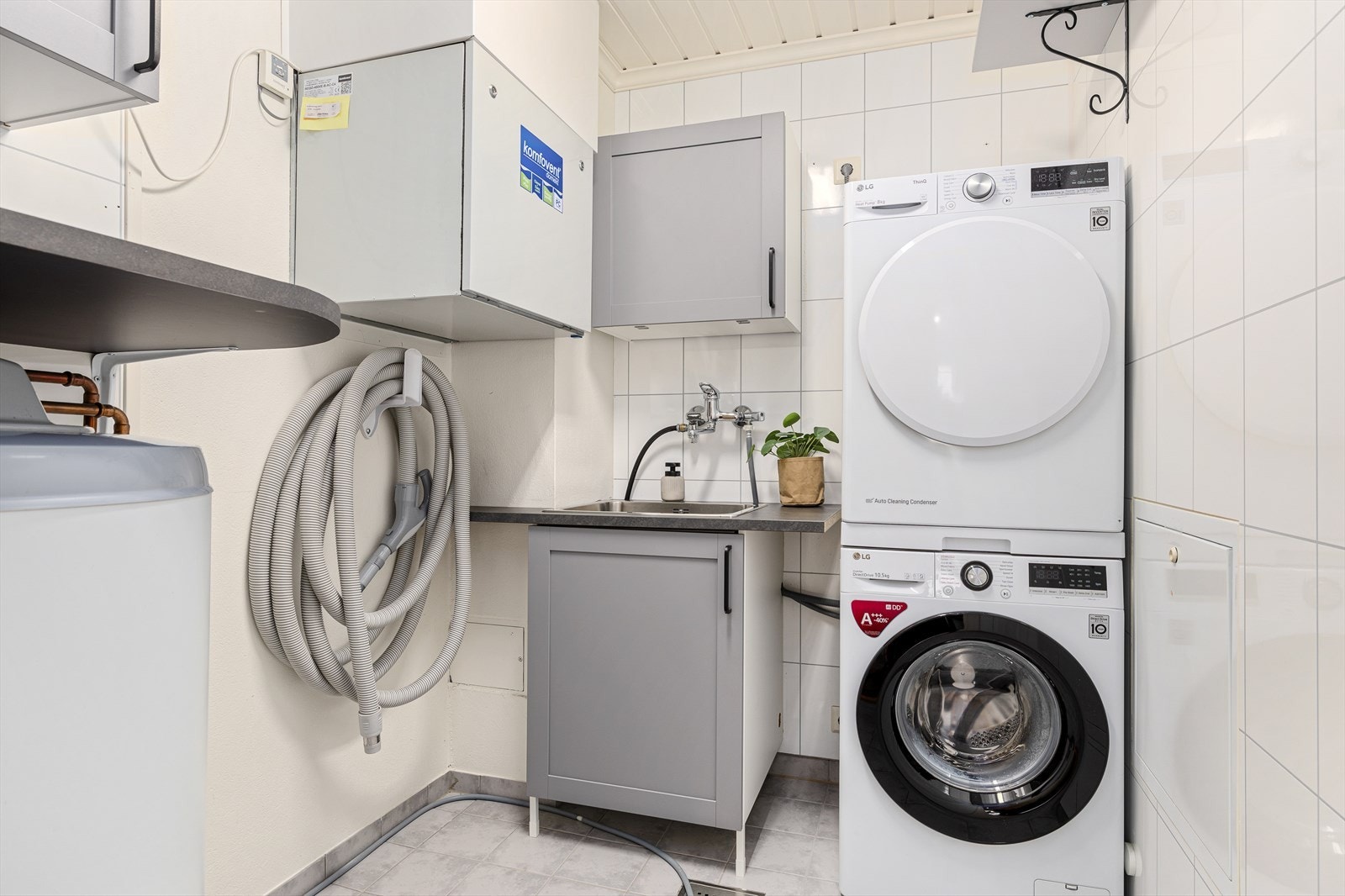 Vaskerom/teknisk rom med varmtvannsbereder, utslagsvask, og plass til vaskemaskin og tørketrommel. Galleribilde