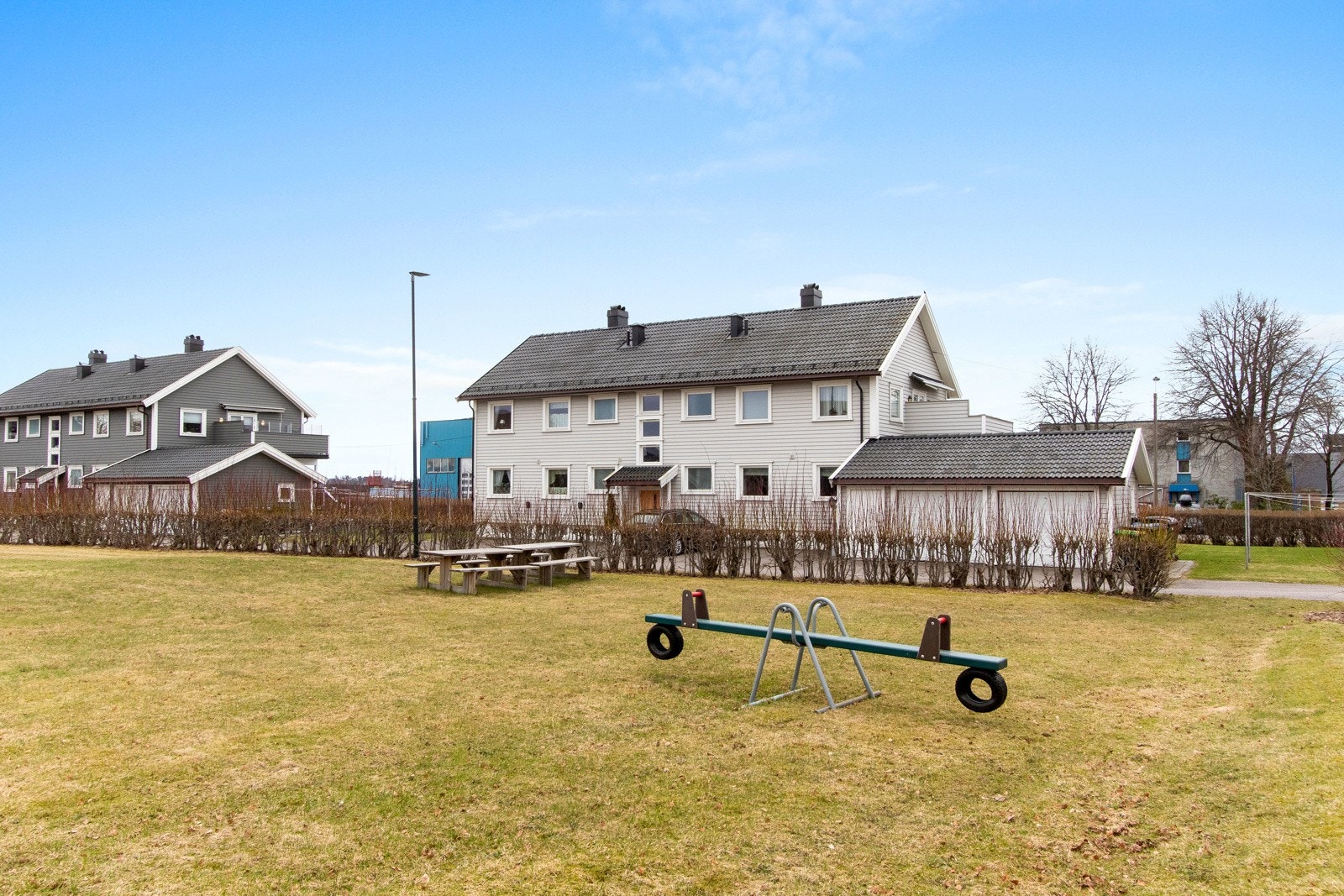 Store fellesarealer med sittebenker og lekestativer som skaper en sosial møteplass for beboerne. Galleribilde