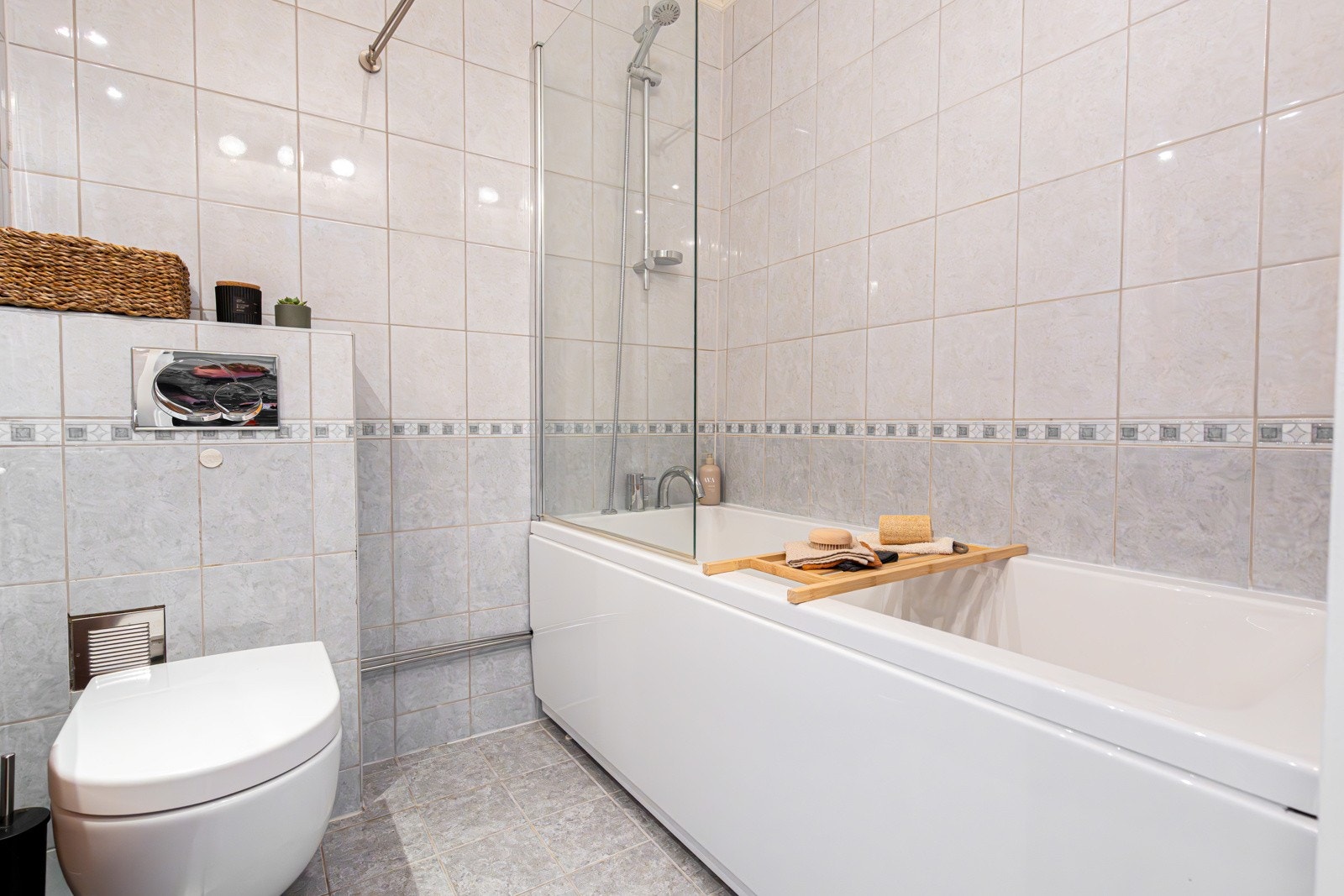 Badet i underetasjen har fliser på gulv og vegger og varmekabler. Badekar fra 2019. Galleribilde