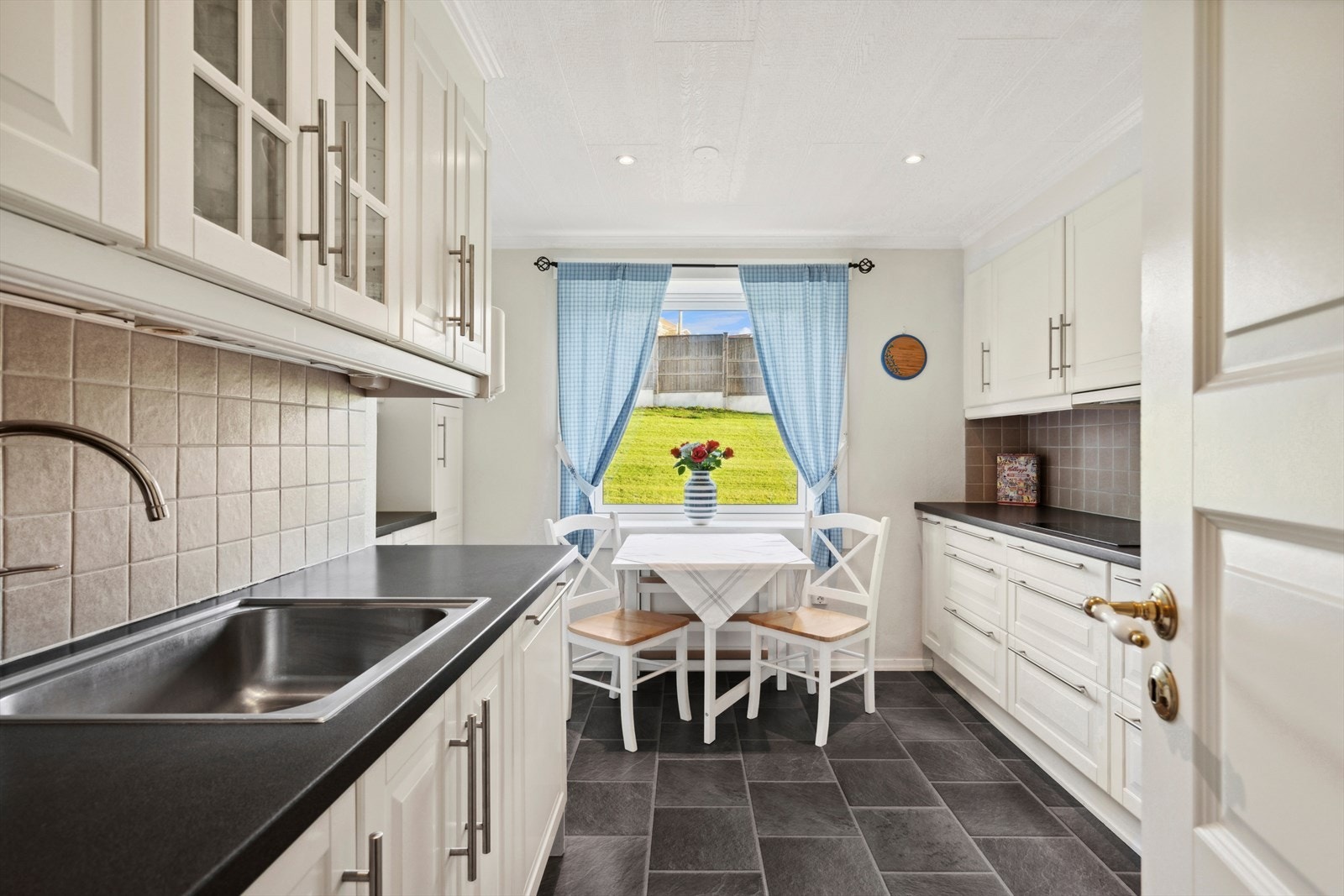 Kjøkkenet er separat med tilgang fra entré og består av en klassisk innredning med profilerte fronter og enkelte glassfronter i overskap som har belysning under. Galleribilde