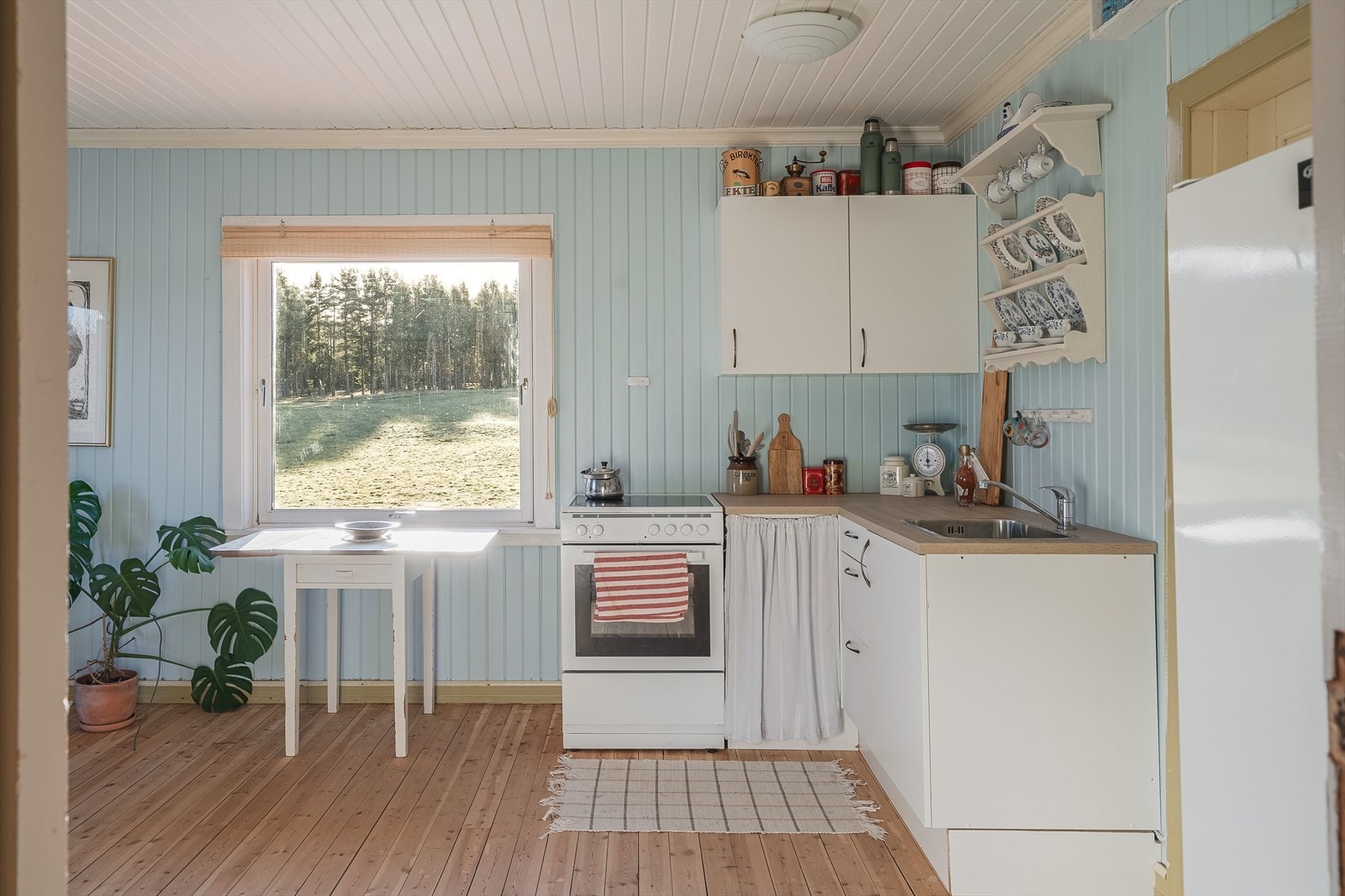 Nyere kjøkkeninnredning fra 2022 med hvite glatte fronter og laminert benkeplate med nedfelt oppvaskkum. Galleribilde