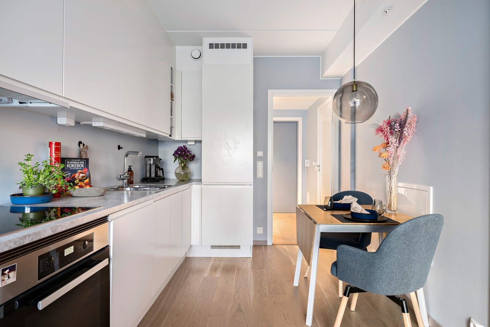 Moderne kjøkkeninnredning med hvite, slette fronter og laminat benkeplate Galleribilde