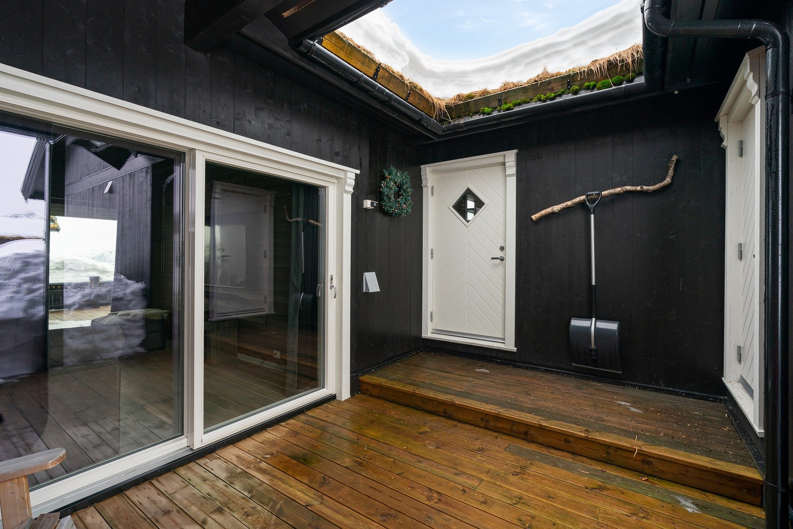 Delvis overbygget inngangsparti på baksiden av hytten Galleribilde