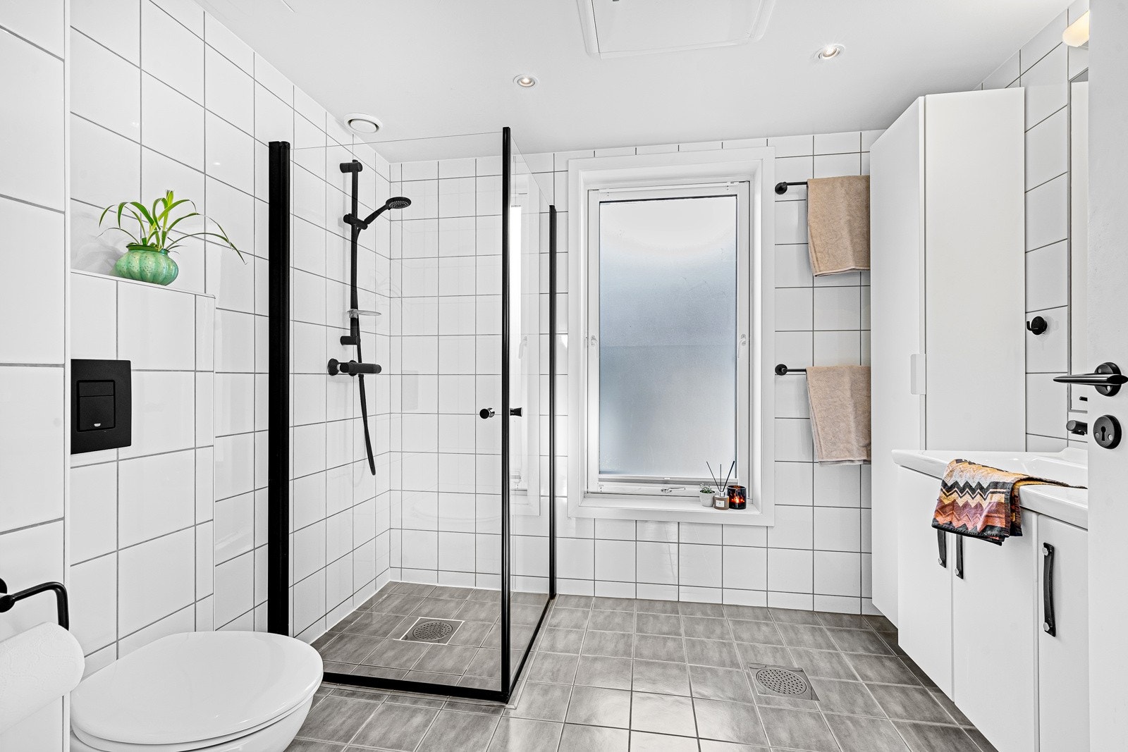 Badet er modernisert med sorte detaljer i tillegg til ekstra skapplass. Galleribilde