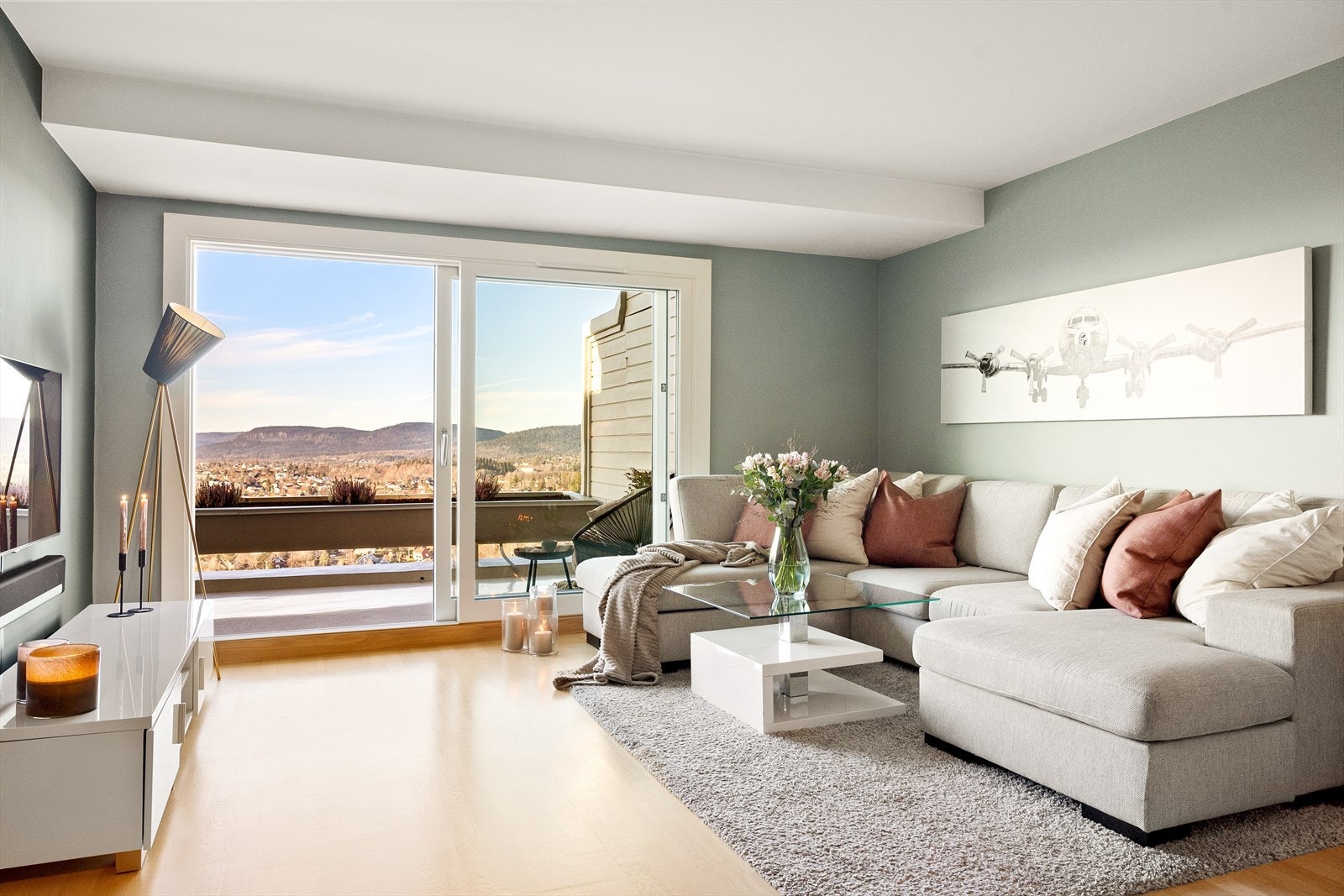 Romslig og moderne stue malt i nøytrale og lune farger gir en innbydende og avslappende atmosfære. Her er det rikelig med plass til en større sittegruppe med tilhørende møbler Galleribilde