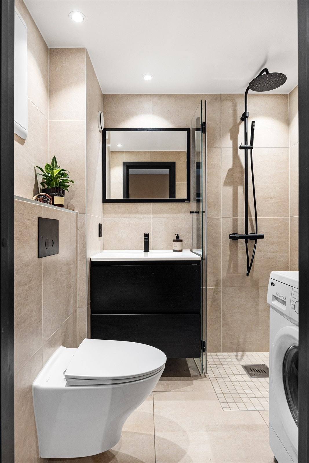 Utstyrt med mekanisk avtrekk, innfellbare dusjdører, veggmontert wc og servantskap med ett greps blandebatteri fra Tapwell Galleribilde