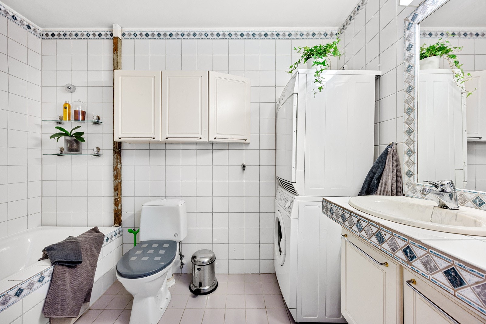 Badet er flislagt og innredet med opplegg for vaskemaskin og kondenstørketrommel i søyleløsning. Galleribilde