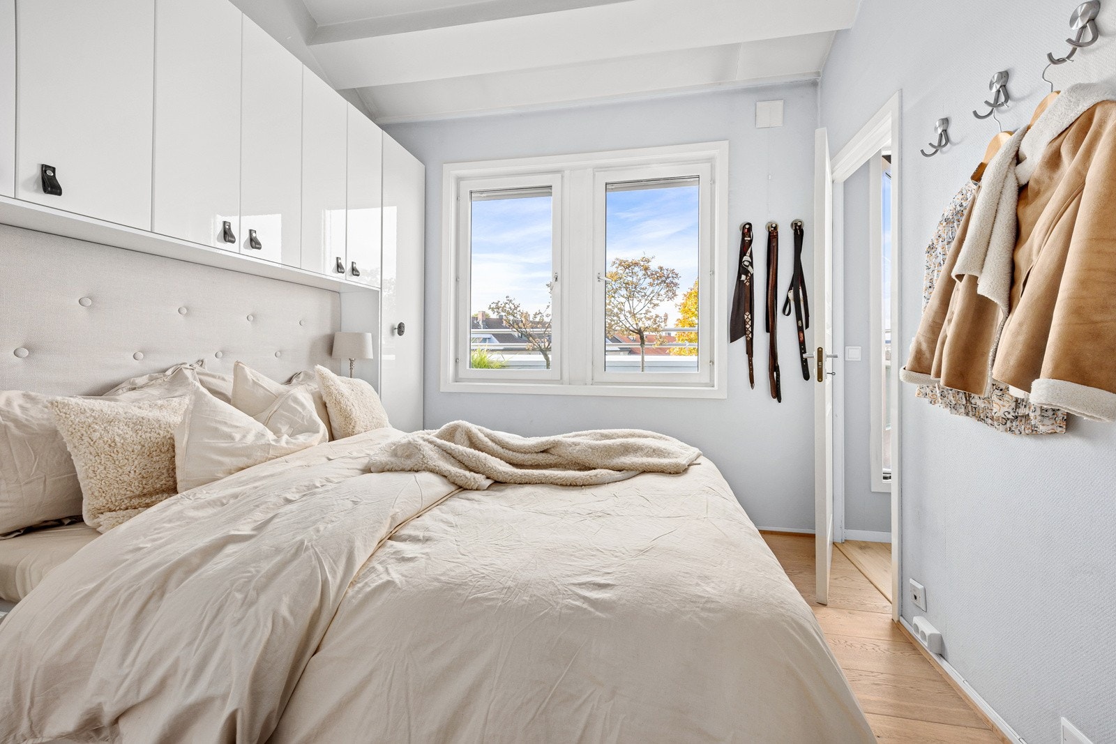 Soverommet har lysmalte overflater, enstavs parkettgulv og vinduer vendt mot egen balkong. Galleribilde