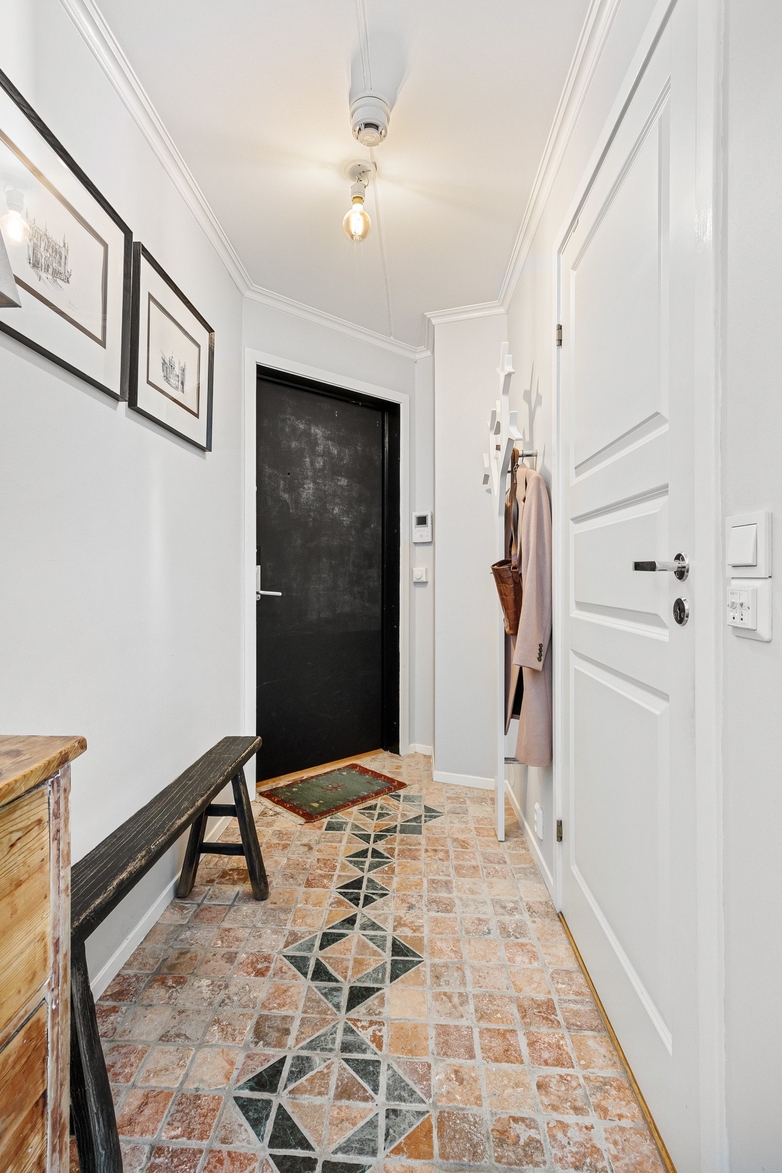 Entreen er lys og innbydende med rustikke fliser på gulvet, lysmalte vegger og plass til garderobeløsning. Galleribilde