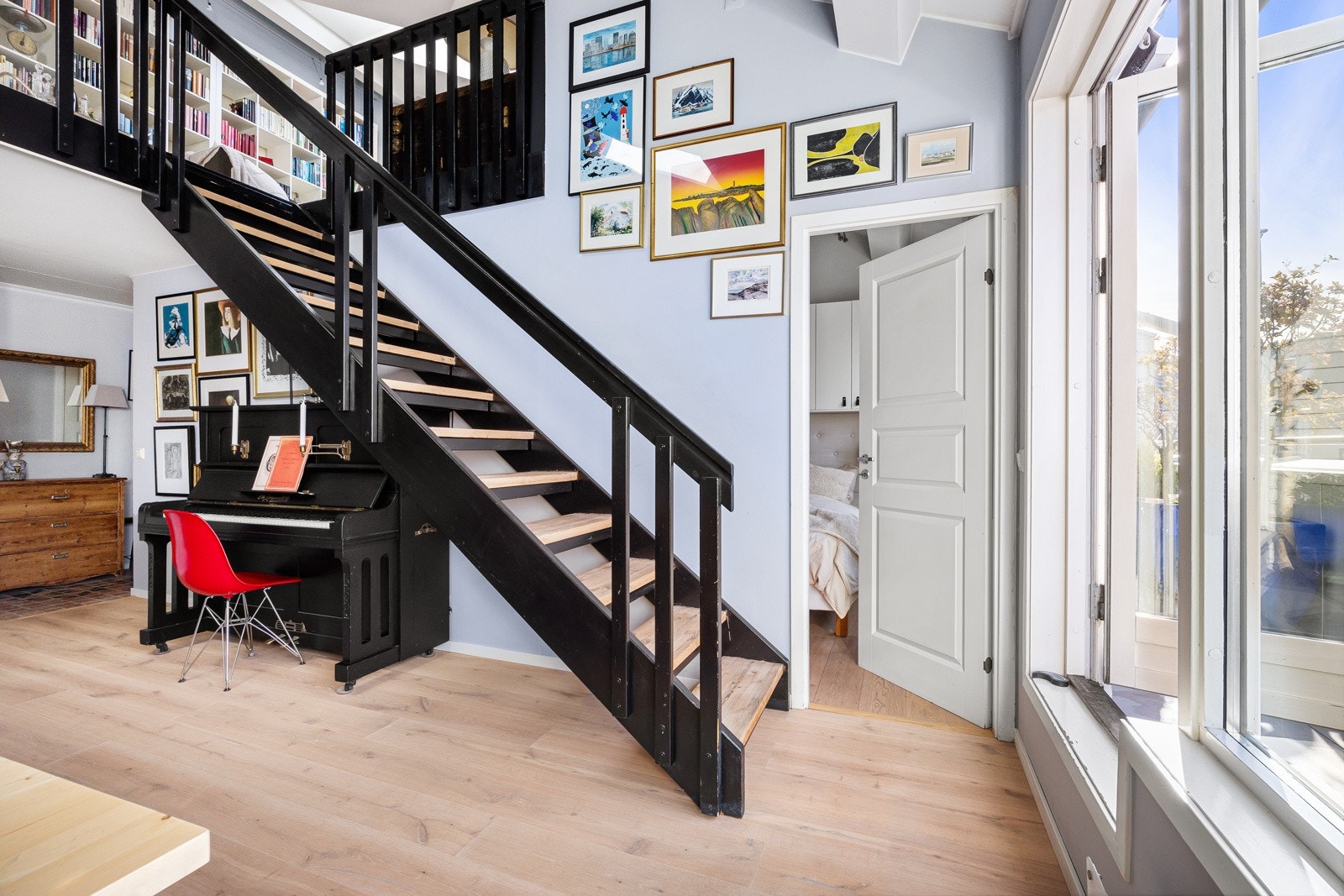 Store vinduer langs endeveggen i stuen gir rikelig med dagslys, og de lyse overflatene understreker den lette følelsen. Galleribilde