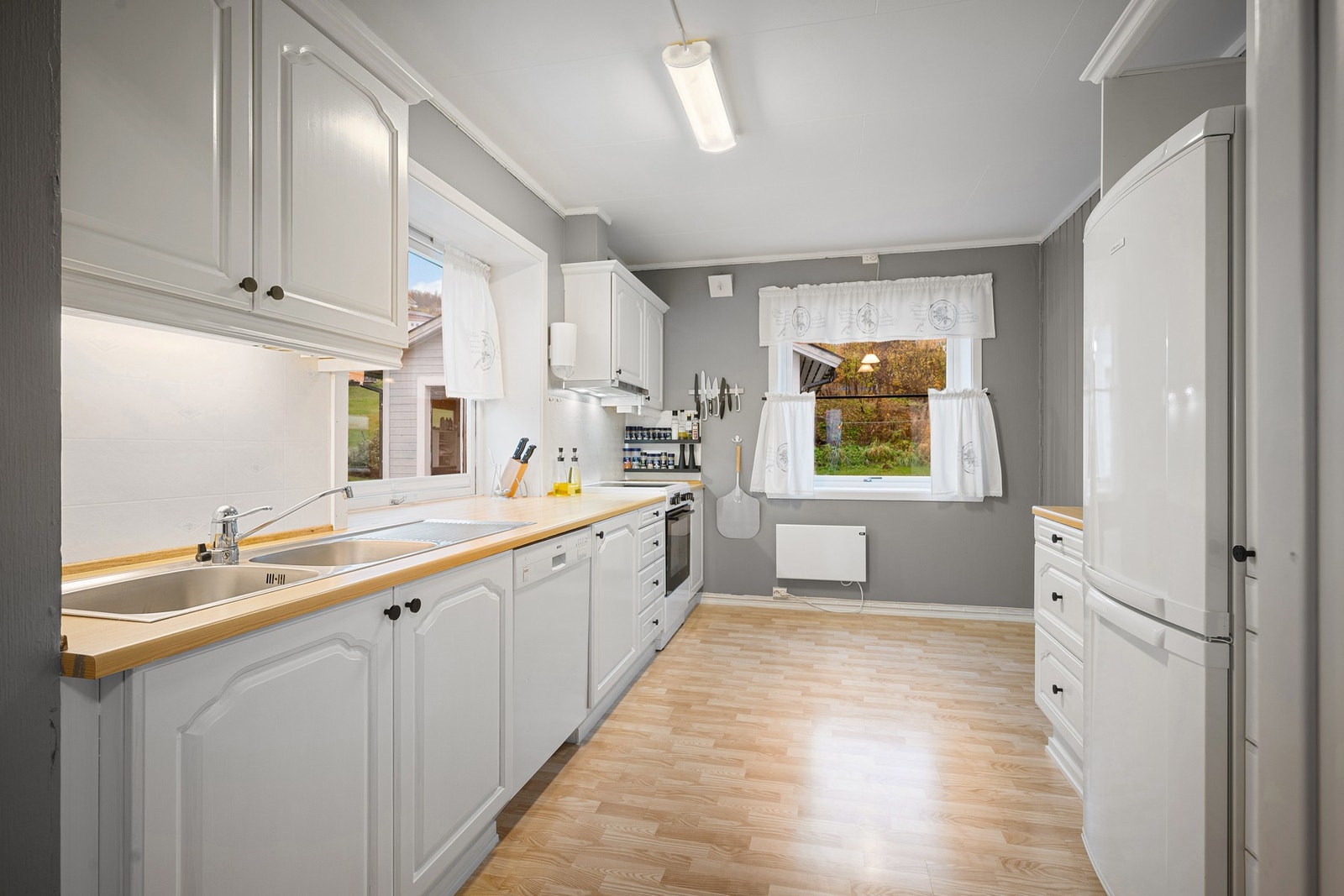 Videre har vi et koselig kjøkken med innredning i klassisk stil, med profilerte fronter og benkeplate av laminat Galleribilde