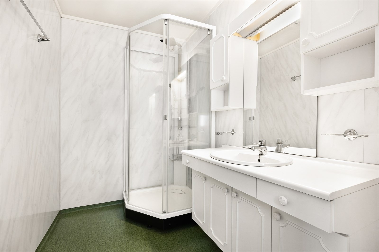 Baderommet er praktisk med dusjkabinett, belegg på gulvet og plater på vegg. Galleribilde