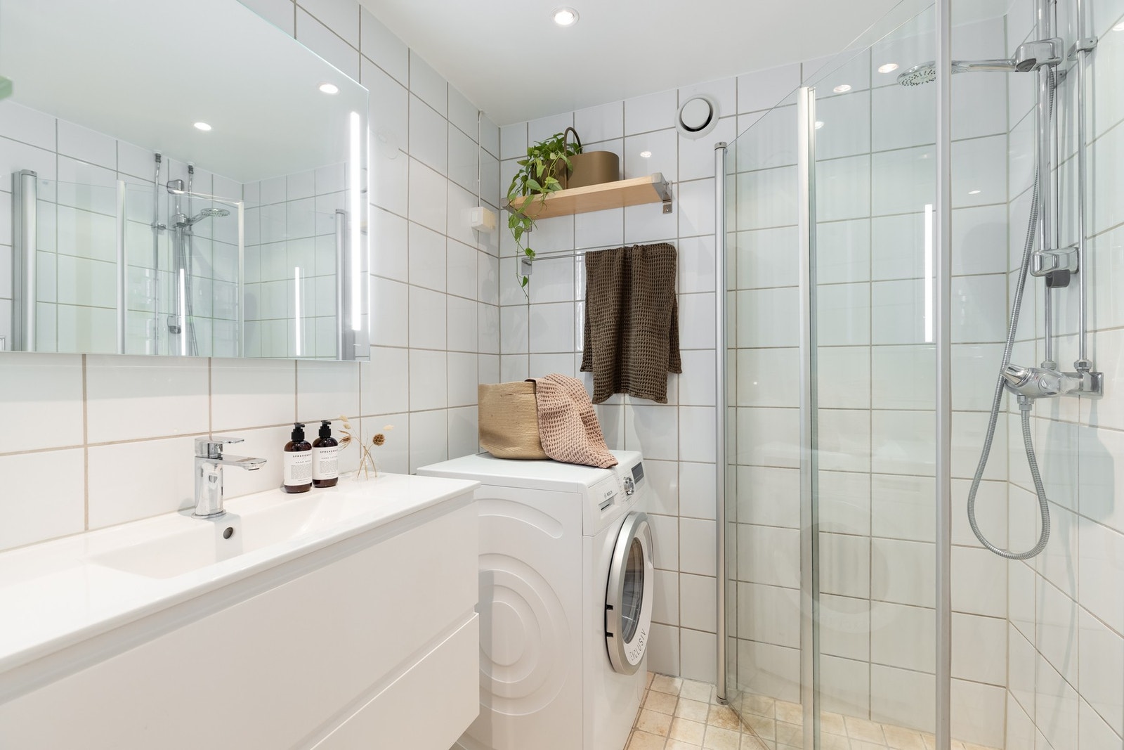 Boligen har ett lyst, flislagt baderom med varme i gulv. Galleribilde