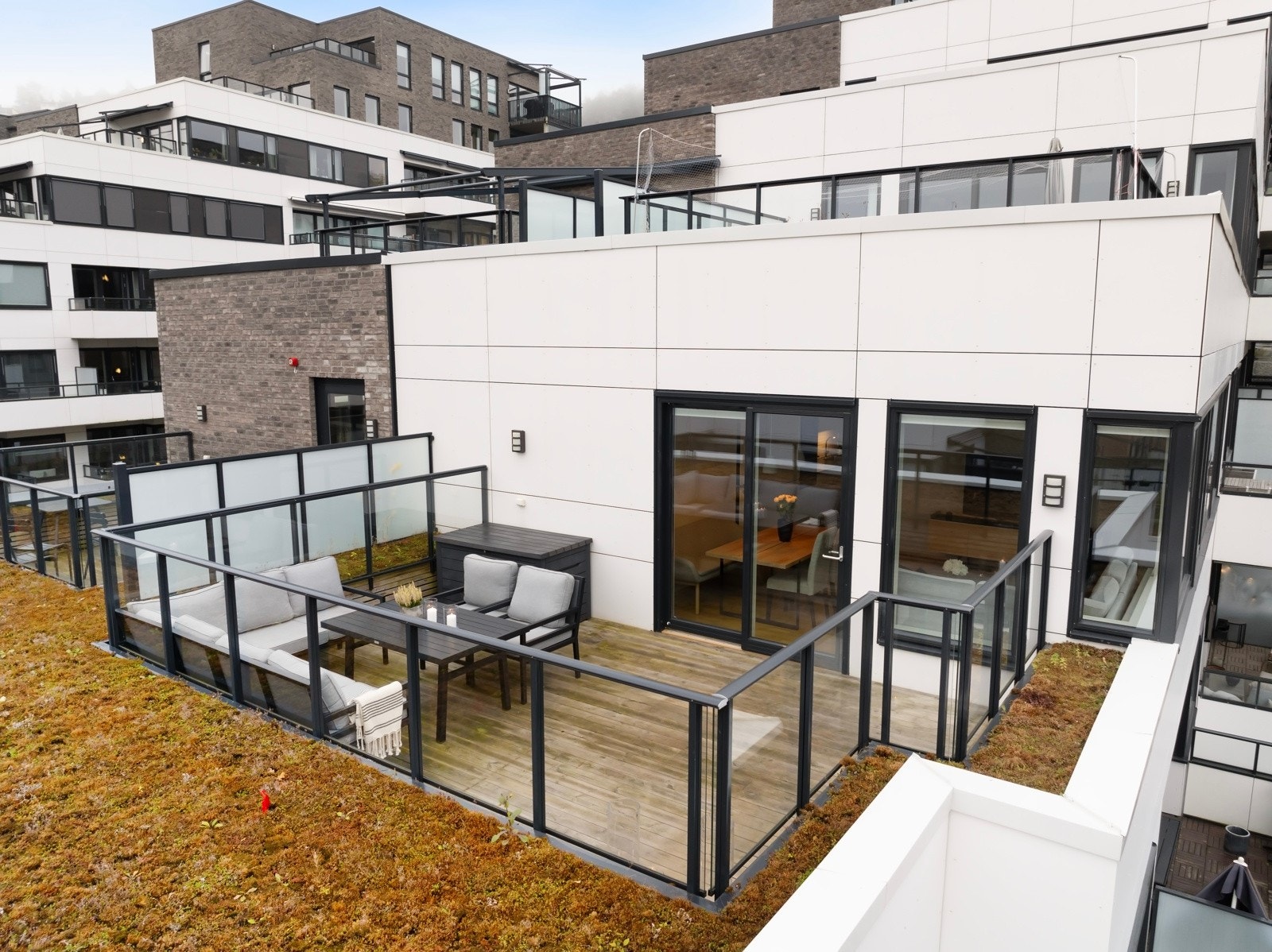 Terrassen har trykkimpregnert dekke og rekkverk i glass. Galleribilde