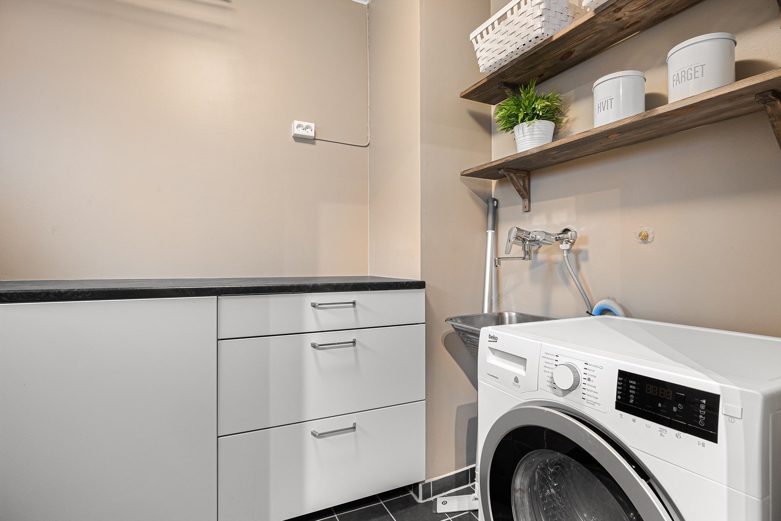 Ved kjøkkenet ligger et praktisk vaskerom med underskap og utslagsvask i laminert benkeplate. Galleribilde
